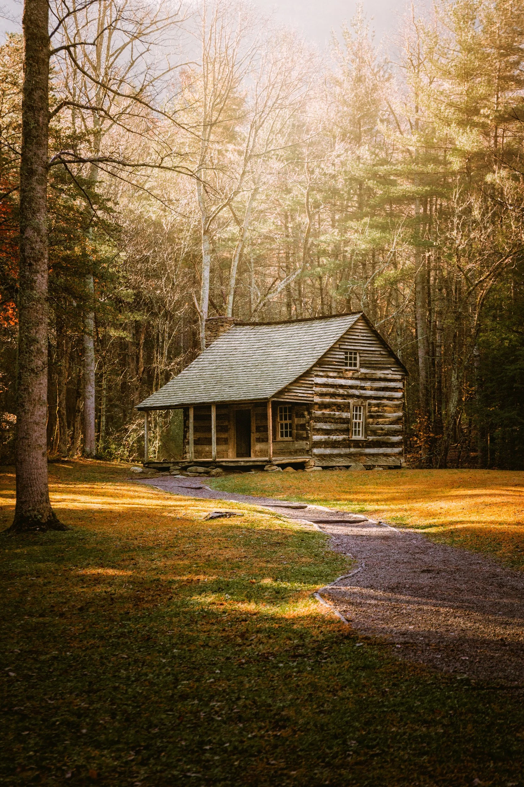 A historic log cabin set against forested ridges in Cades Cove, Great Smoky Mountains National Park, Tennessee, by Ryan L. Smith