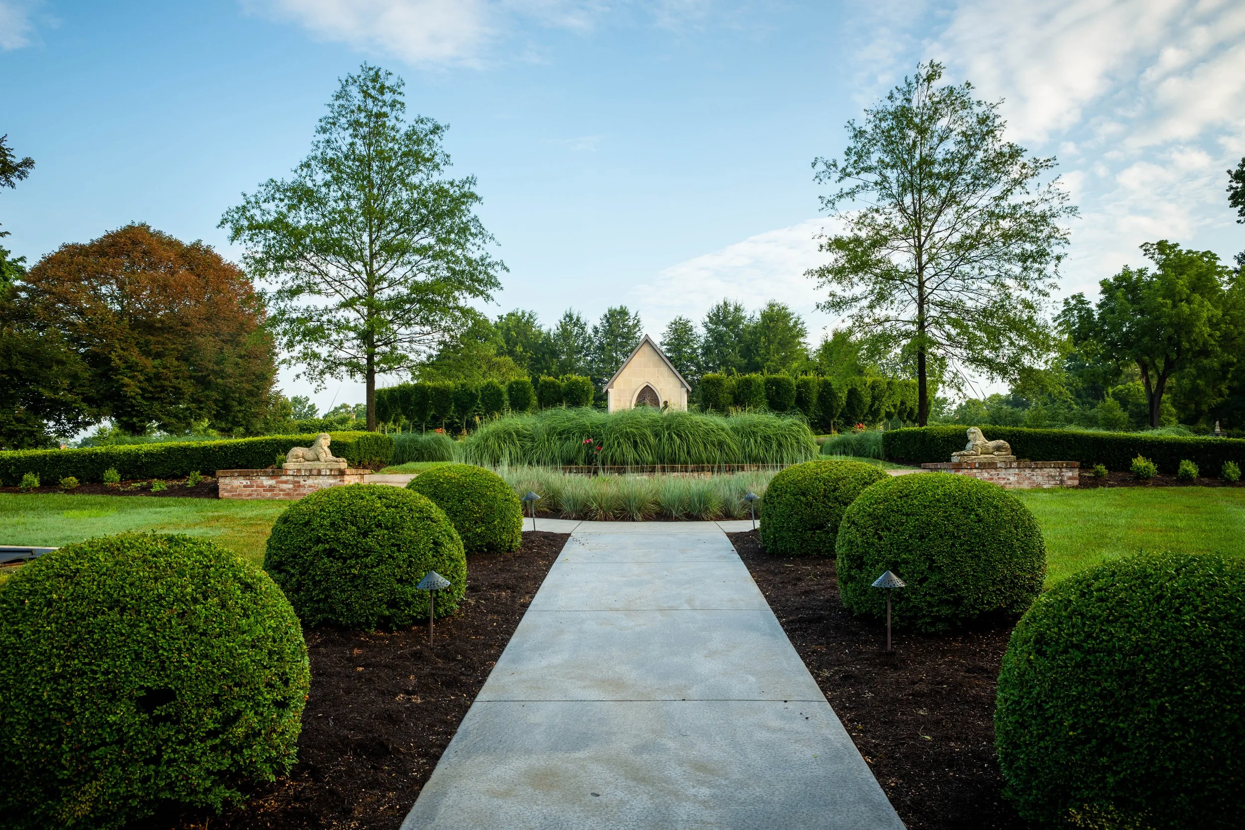 Formal gardens with boxwood hedges and stone chapel at Mt. Brilliant Farm in Lexington, Kentucky