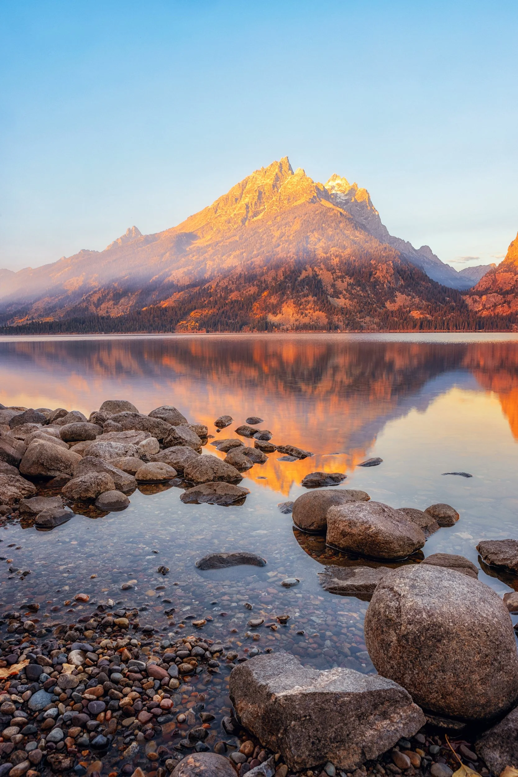 Sunrise light on the Teton Range above the still water of Jenny Lake, Grand Teton National Park, Wyoming, vertical print by Ryan L. Smith