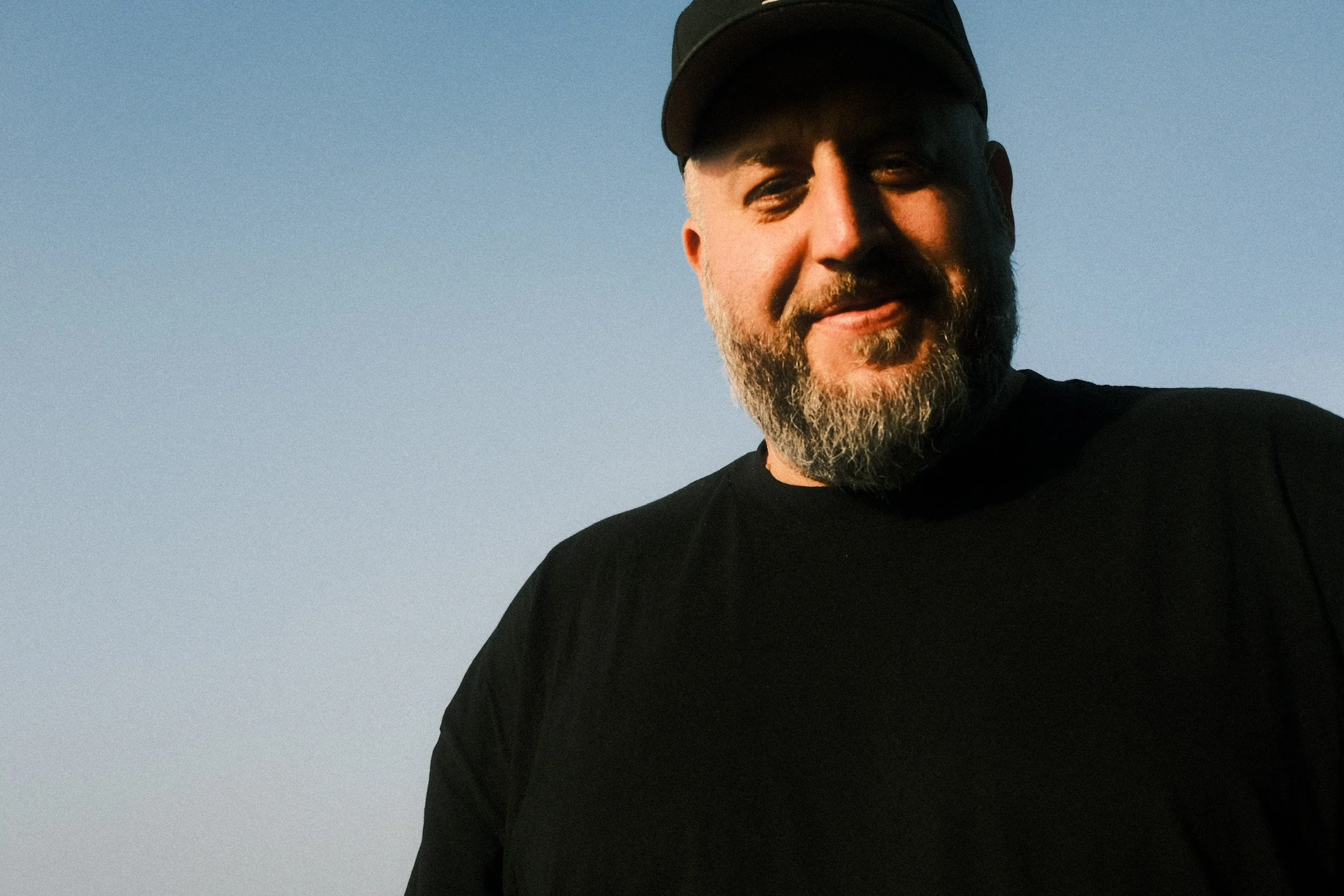 Portrait of Ryan L. Smith outdoors under a clear blue sky.