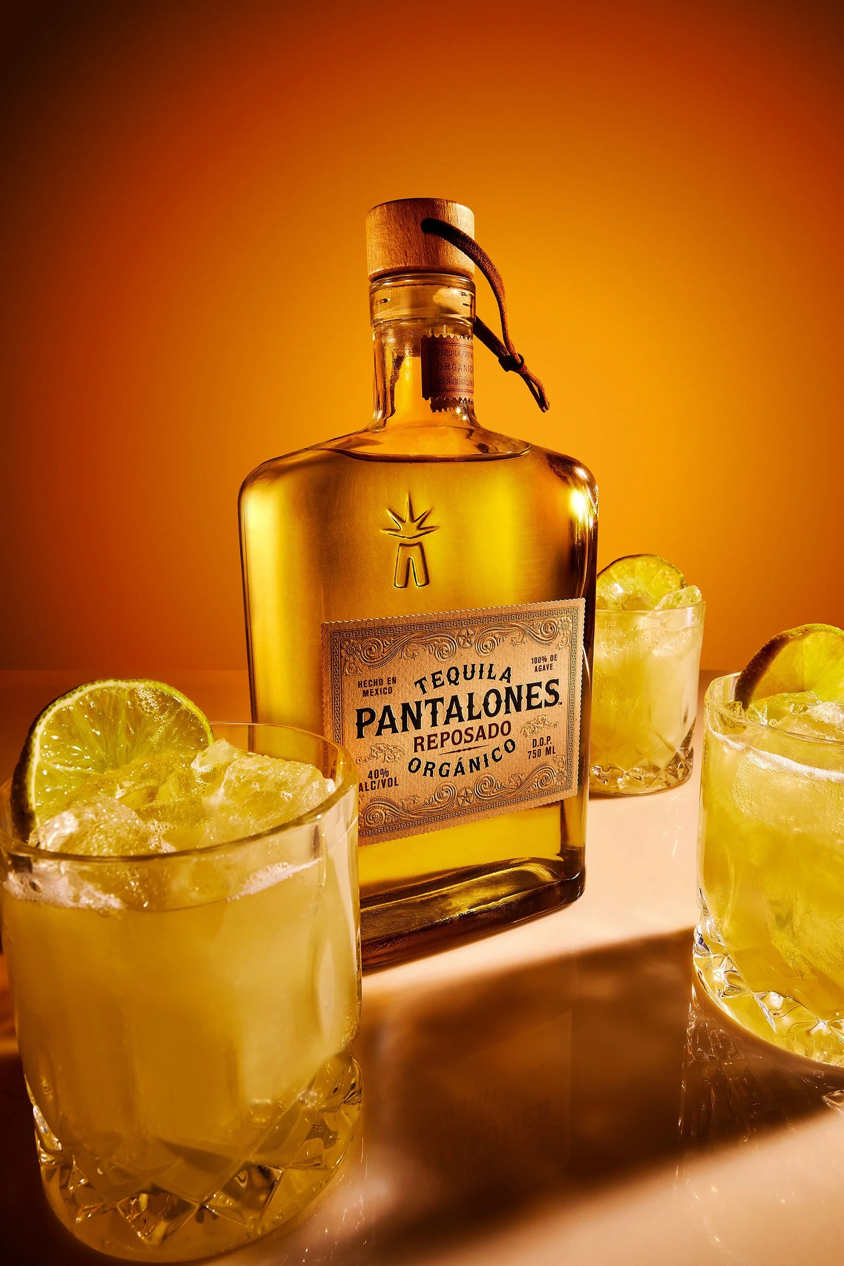 Pantalones Reposado organic tequila bottle with margaritas and lime garnish, beverage photography by Ryan L. Smith