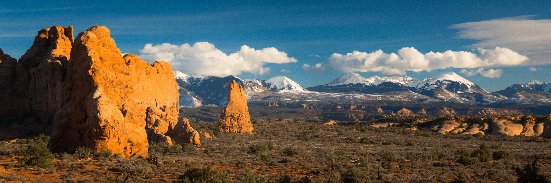 Red rock formations in Arches National Park with the snow capped La Sal Mountains in the distance, Utah, by Ryan L. Smith