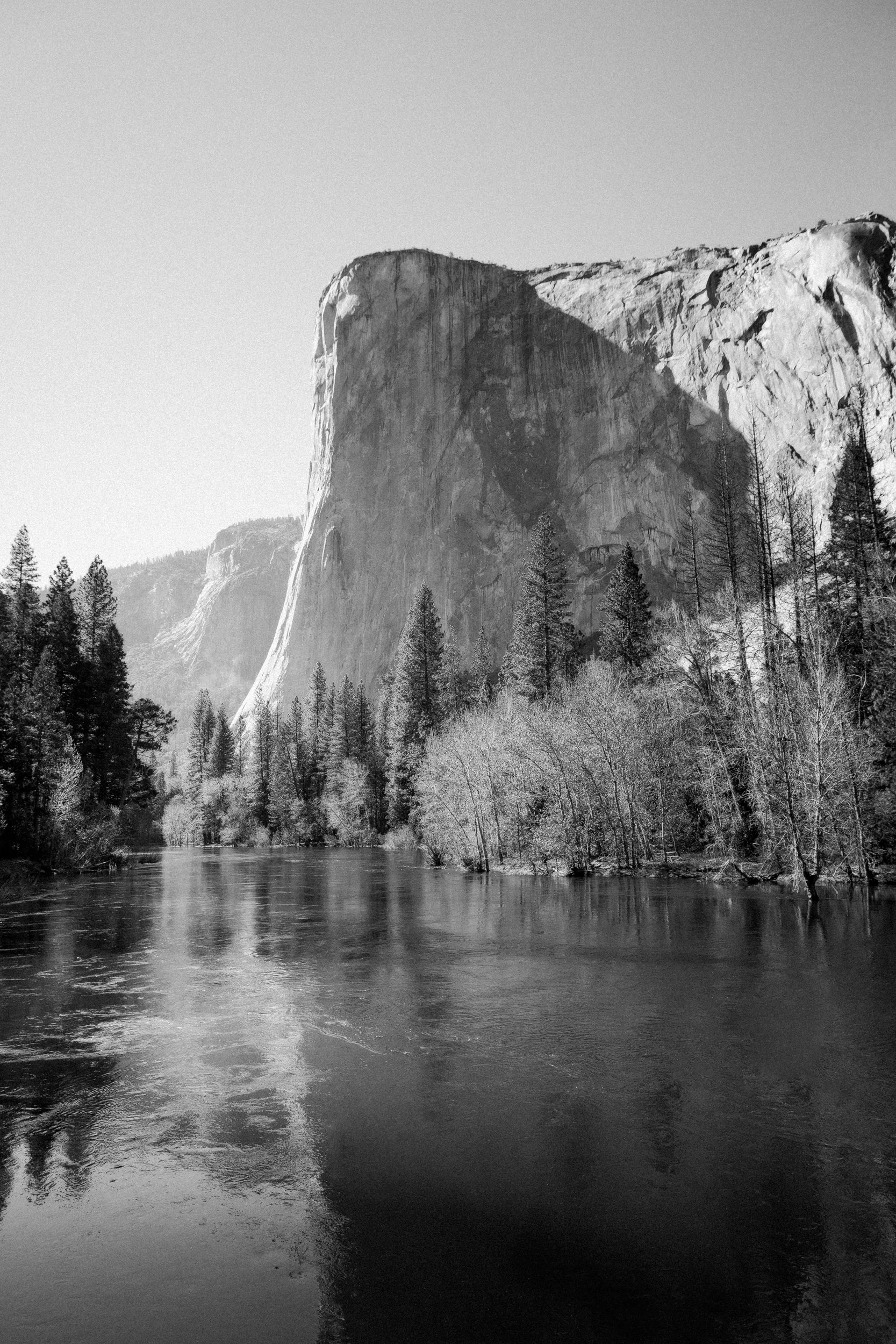 Black and white photograph of El Capitan rising above the Merced River, Yosemite National Park, California, by Ryan L. Smith
