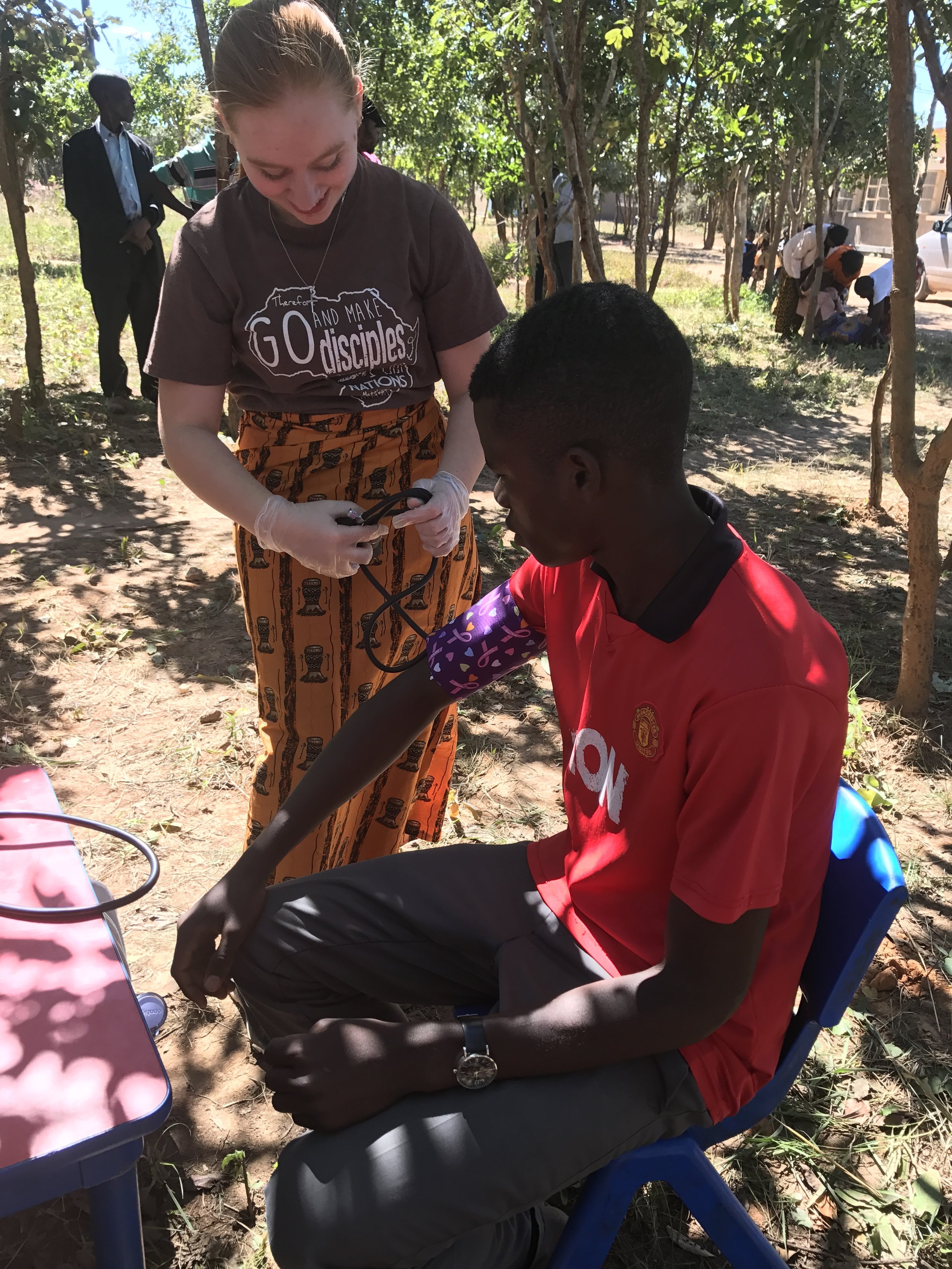 A future RN doing a BP during a mobile clinic outreach 