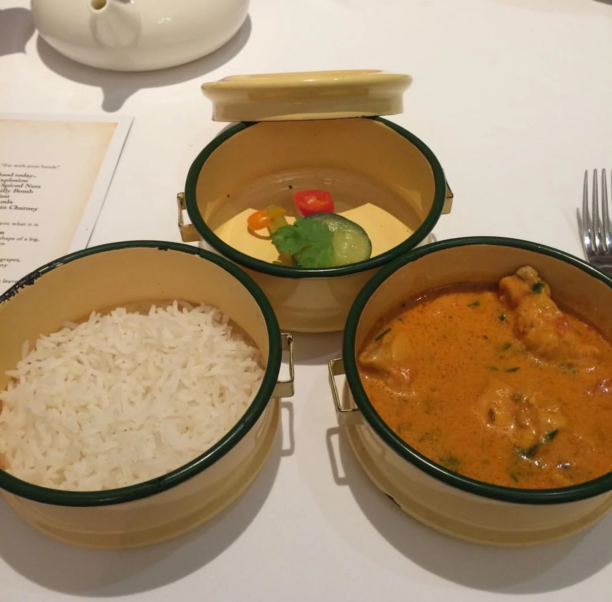 Chicken tikka masala served with naan, rice and pickled veg in a tiffin box.