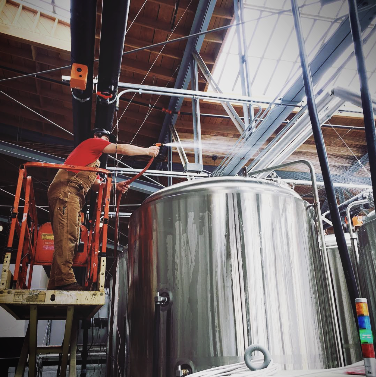 Brewer tending to fermenting tanks.