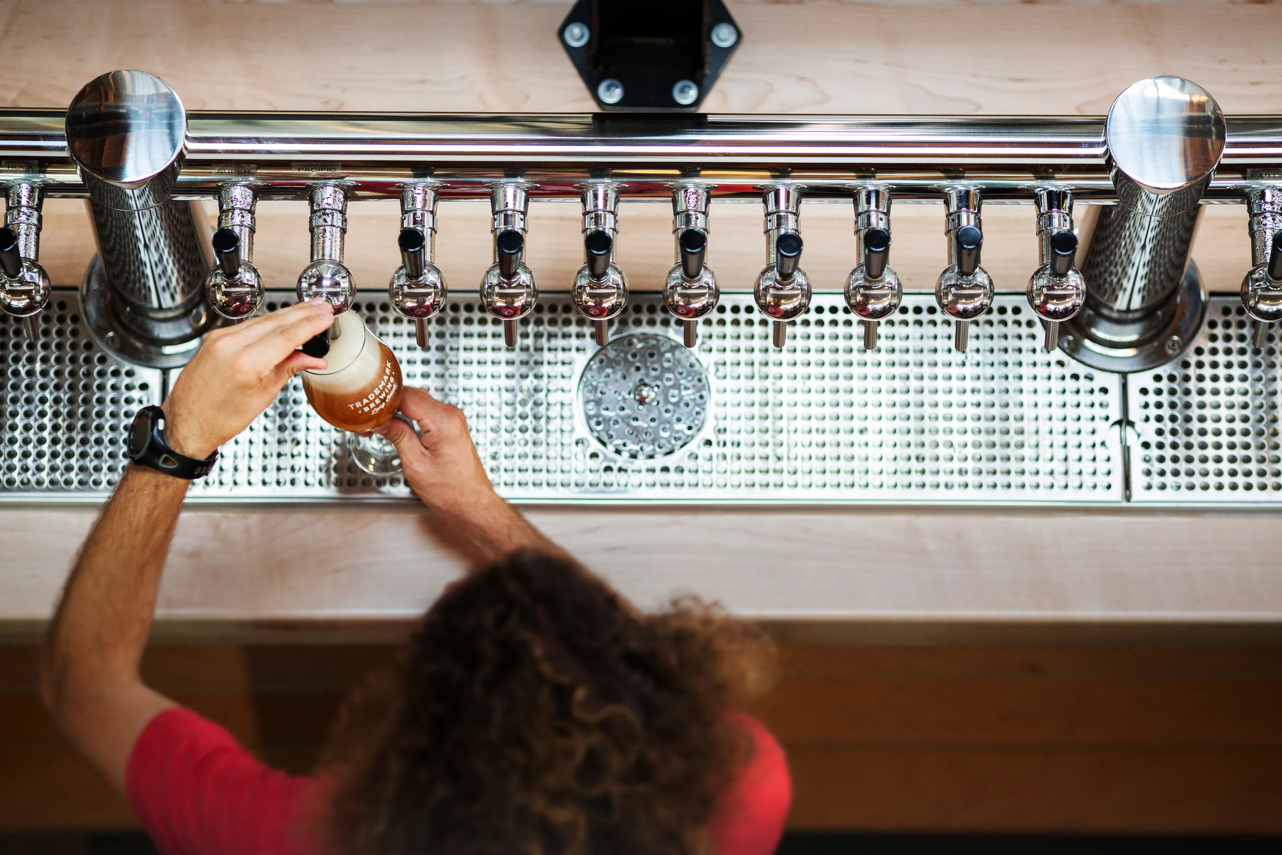 Overhead view of bartender pouring beer.