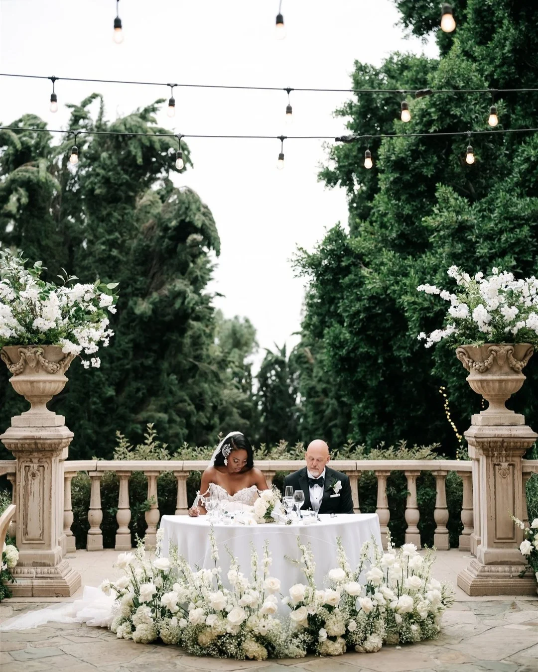 When getting married at Villa Del Sol D'Oro, my favorite seating to recommend for the newlyweds during their reception is a sweetheart table. Nestled between the two columns and urns with the lush green backdrop of the hedges, it really makes for a s