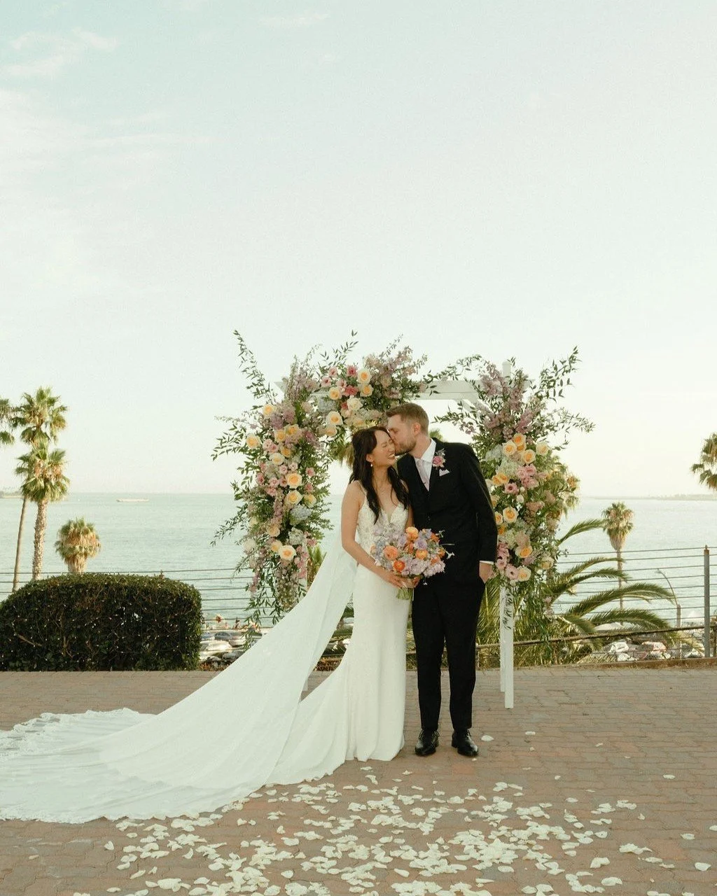 Just a couple of re-newlyweds in front of their wedding arch after saying their I-Do's. So happy we were able to get a pic of them in front of their beautifully decorated arch, and of course in front of the deep blue sea! 

@lbma_events @clairesatthe