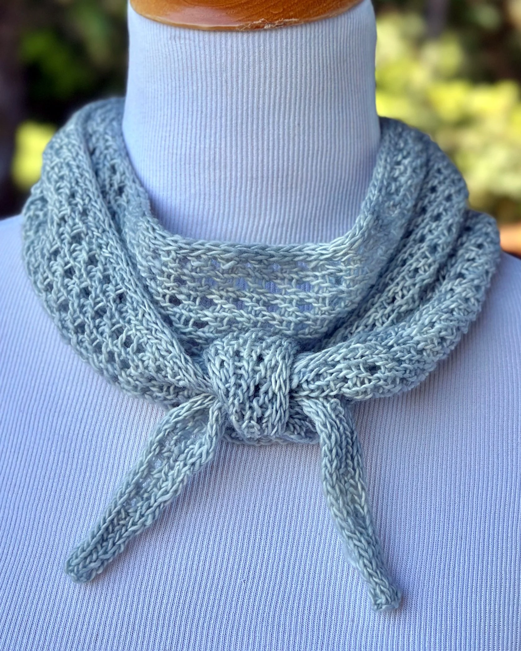Moonbeam Scarf, an easy textured lace knitting pattern, is knotted in front for a casual look that tops off many outfits.