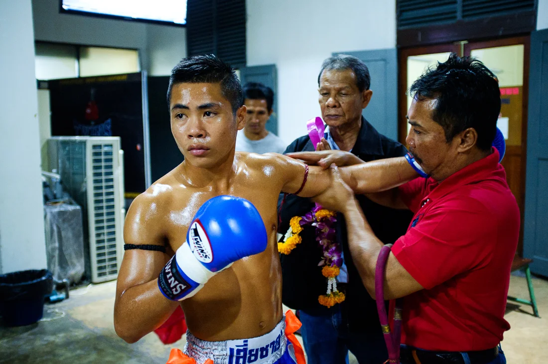  An elder prays over a fighter’s  shoulder for safety.  