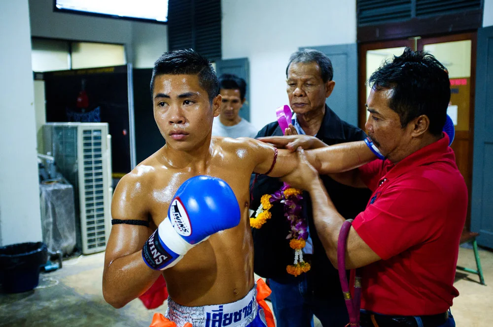  Elder prays over fighter's shoulder before battle, Bangkok Thailand.  