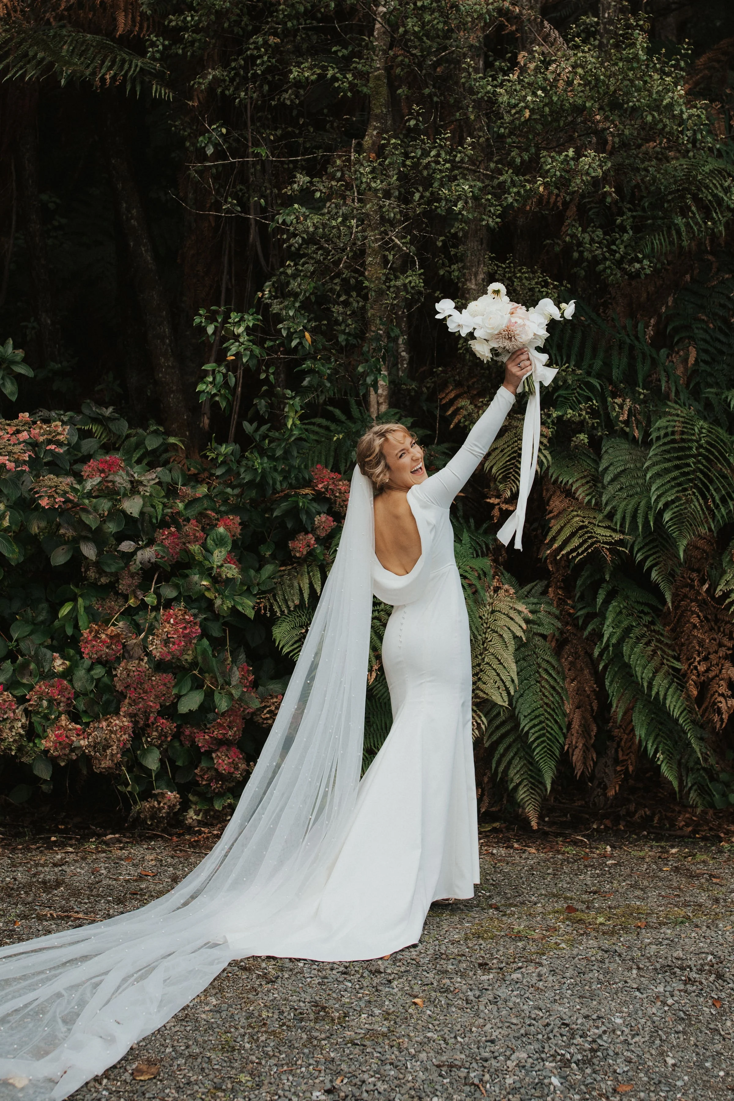 happy-bride-holding-bouquet-in-air-tauranga.jpg