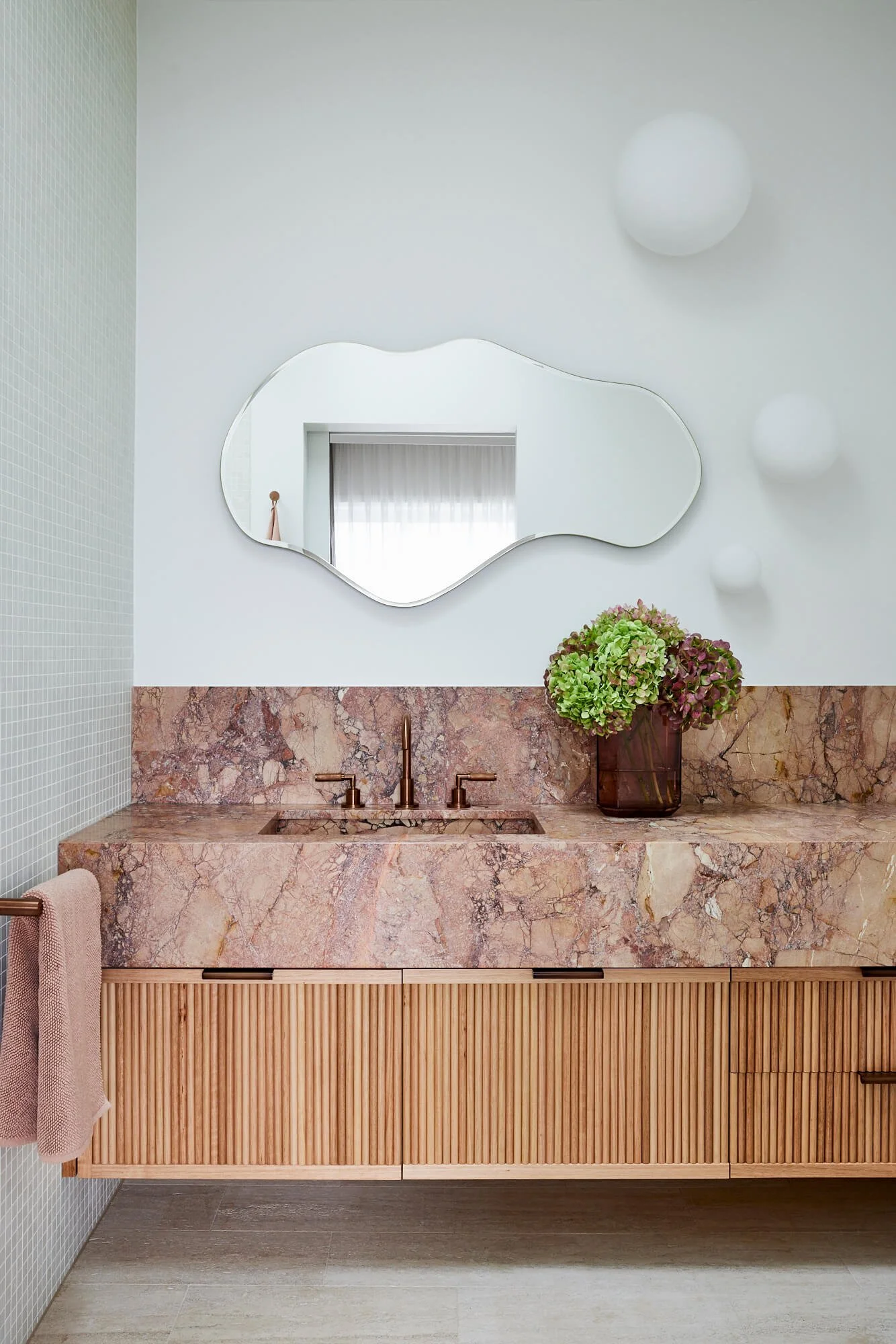 Marble bathroom with curved mirror