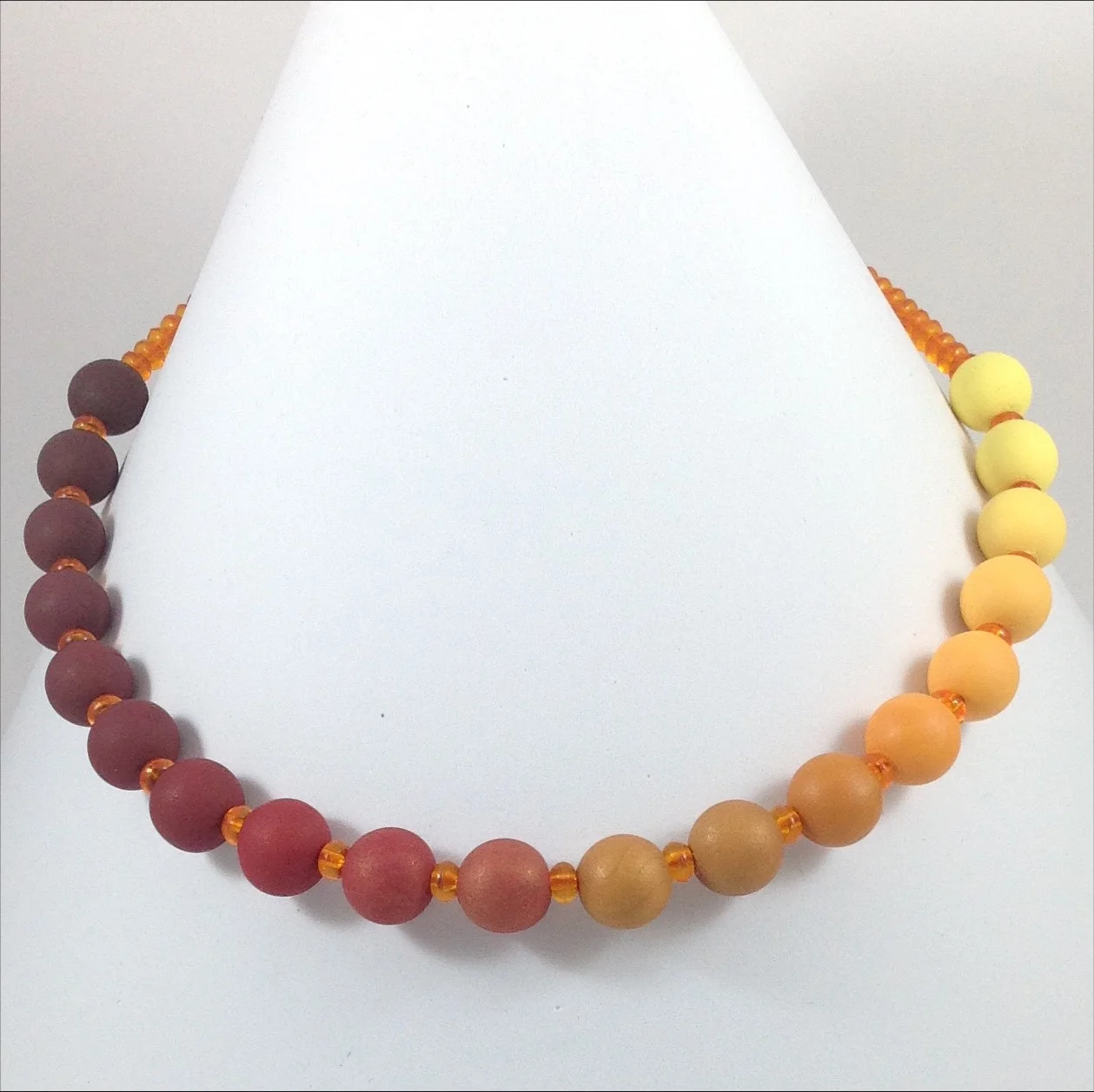yellow brown gradient colour polymer clay bead necklace on stand