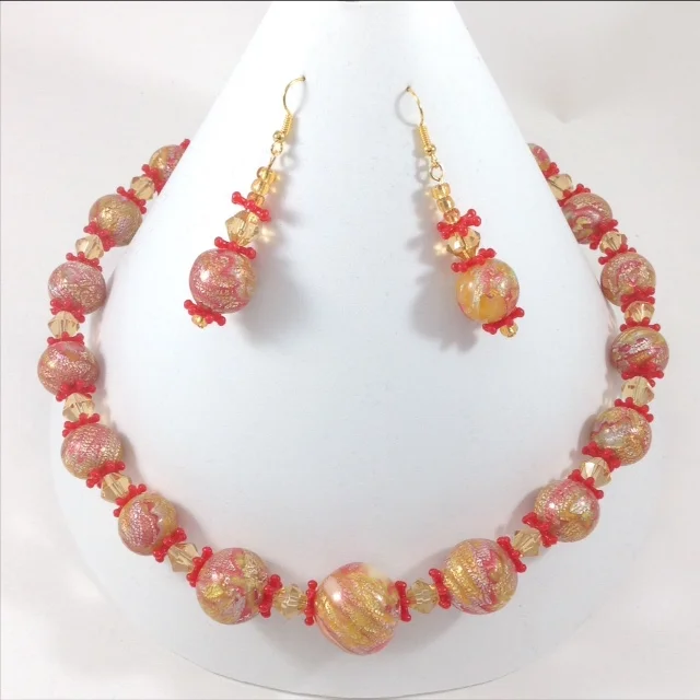 red and yellow mokume gane polymer clay bead necklace and earrings on stand