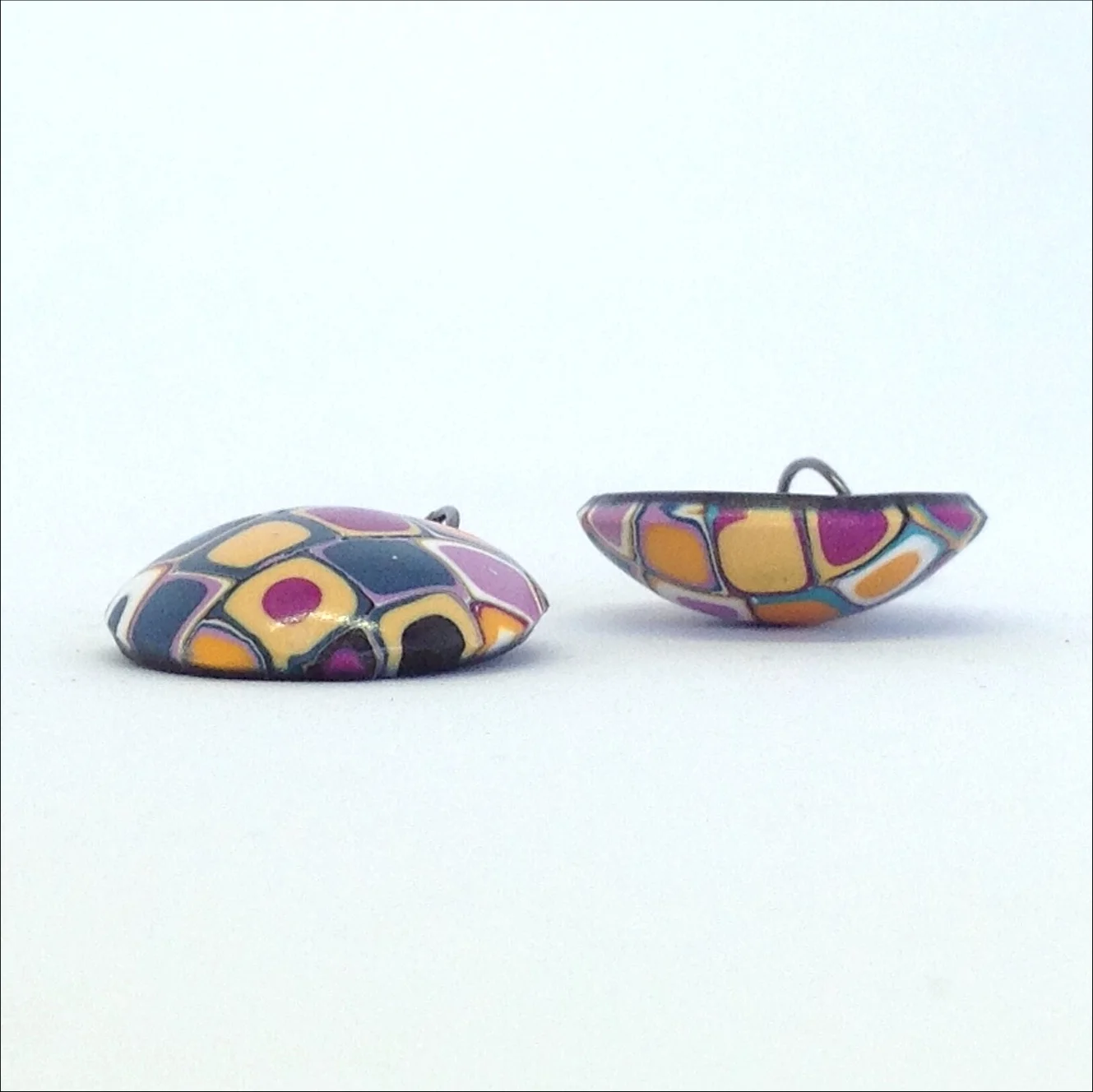 Polymer clay drop earrings purple teal orange showing domed shape