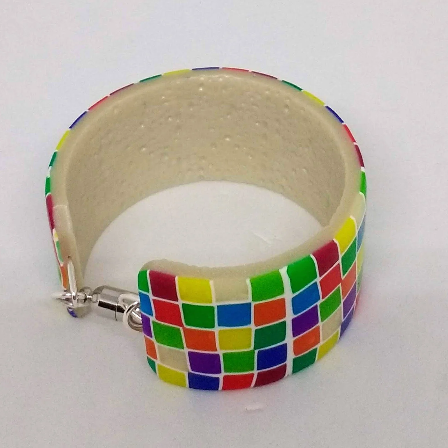 Polymer clay bracelet with multicoloured square design showing magnetic fastening