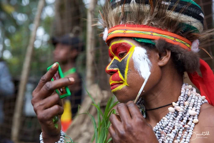 Tribesman applying make up, Goroka - Papua New Guinea - Wild Earth Expeditions
