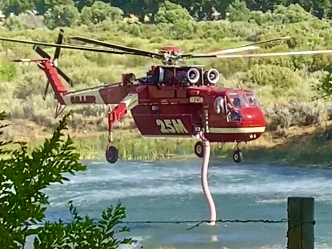 helicopter dips into pond to fight wildfires