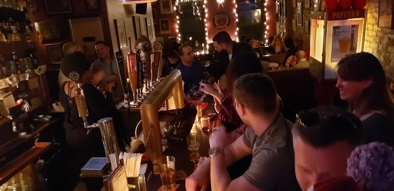 Patrons at the bar enjoying drinks & conversation