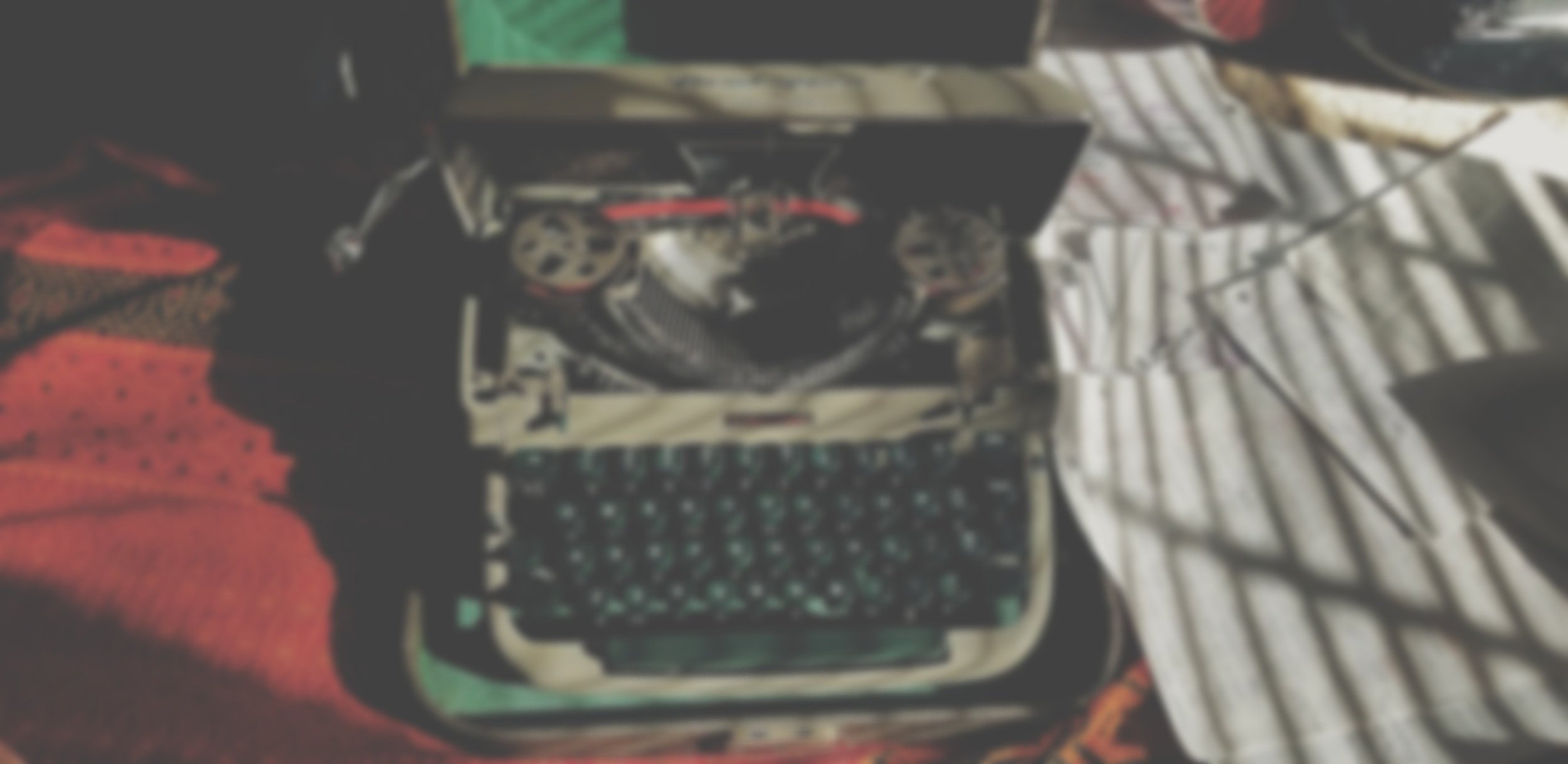 A close-up of a vintage radio with a keyboard, surrounded by various fabric items and patterns.