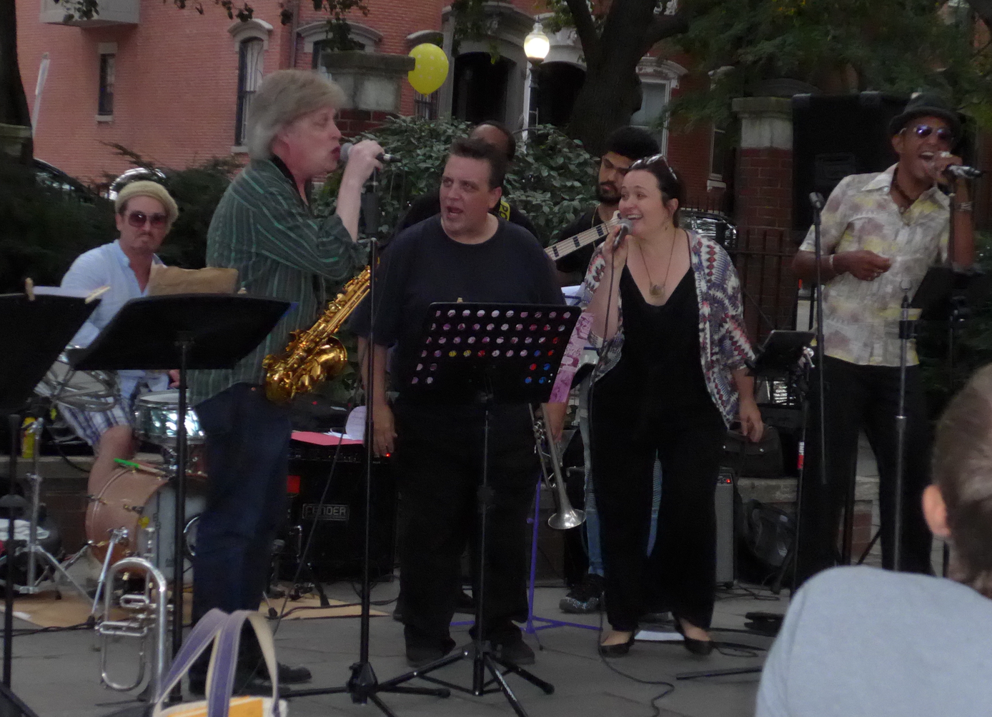 Benny Benson, drums; Pat Loomis, singing with Sax in hand; Scott Aruda, singing with trumpet; Christoff Glaude, bass; Antonio Loomis, guitar; Sarah Seminski and Nephtaliem McCrary, vocalists