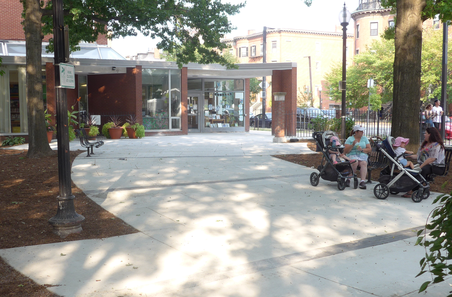A broad plaza/walkway leads from the South End branch to the park entrance at Rutland Square. The chairs in the image were in good-enough condition to preserve for the newly improved park.