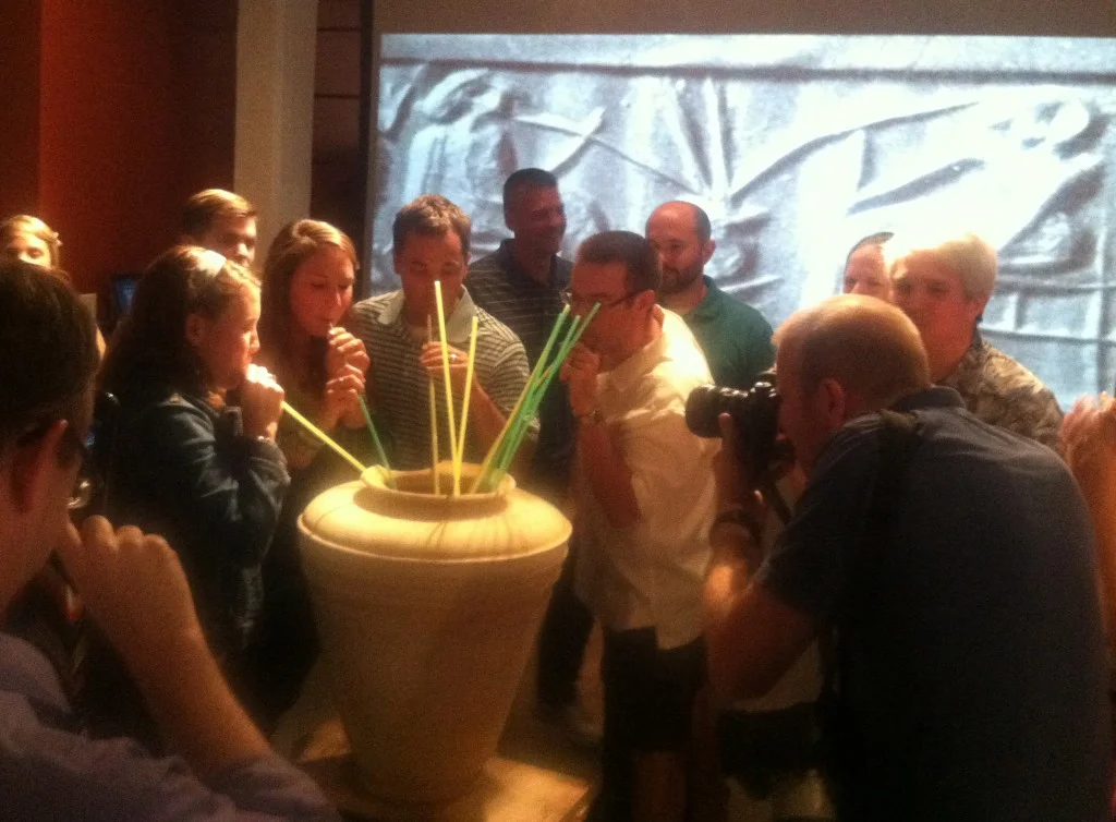Drinking Mesopotamian beer. Adventurous attendees sample Mesopotamian beer through long straws during a tasting event at Great Lakes Brewing Co. in Cleveland, OH. In the background, a cylinder seal impression from ancient Mesopotamia provides guidance. (Photo credit: Kathryn Grossman)