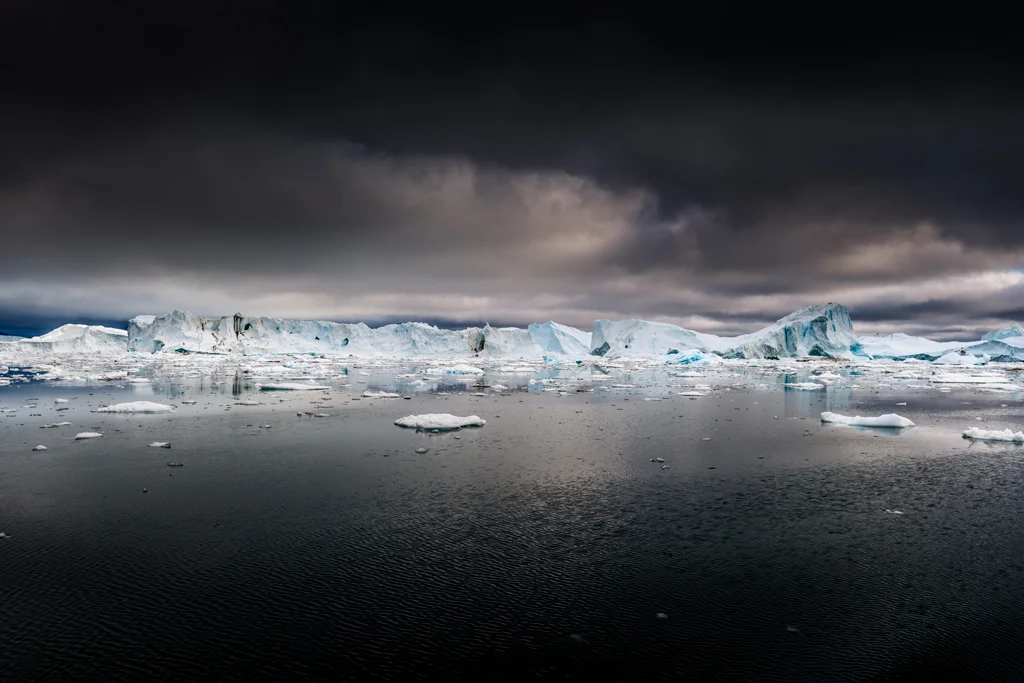 Blue coloured icebergs in dark seas
