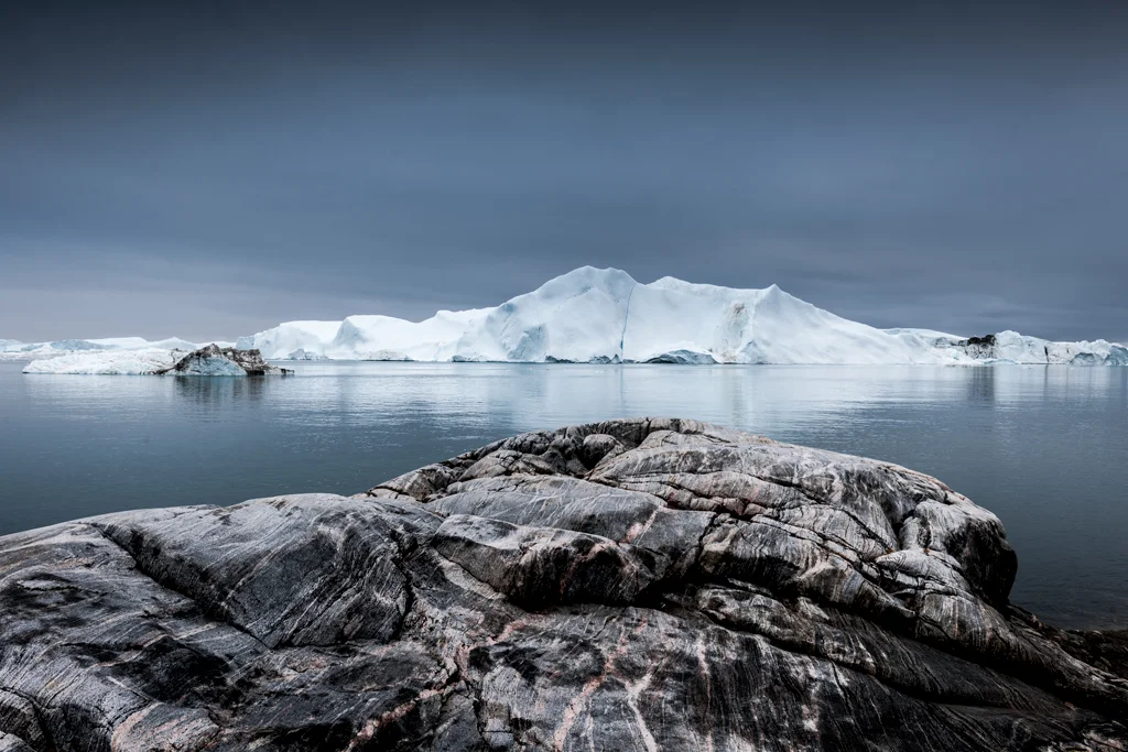 View from rocks towards large iceberg