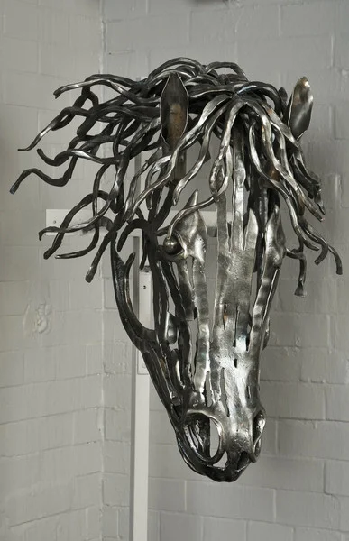 Contemporary hand forged iron horse's head in textured bar steel.