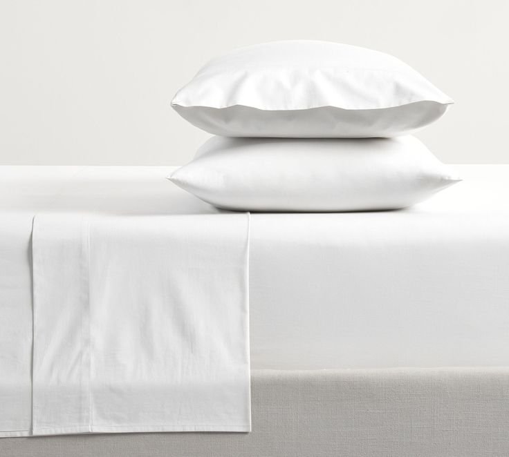  White bed sheet set including fitted sheet and pillow covers. 
