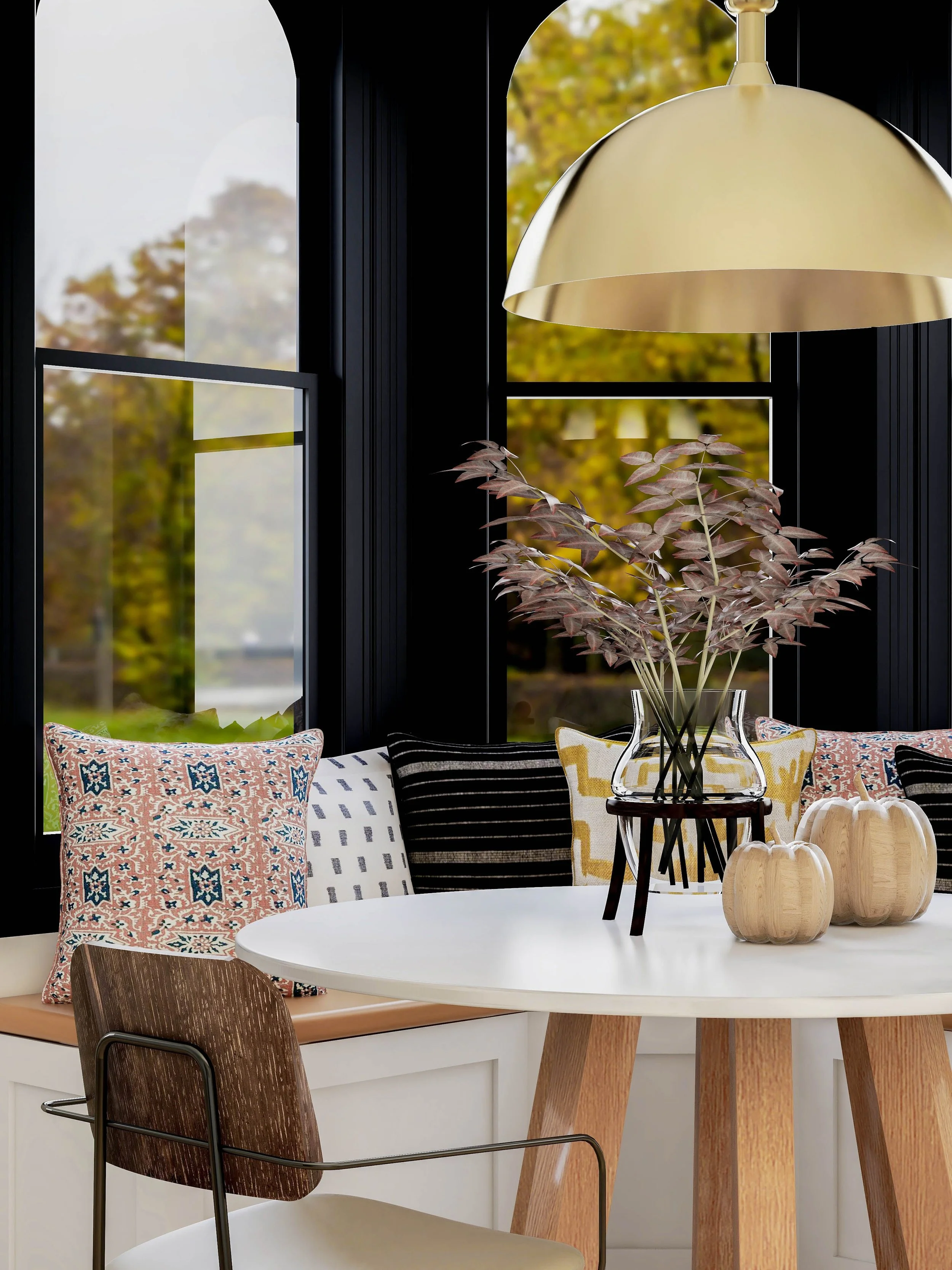 California casual breakfast nook with banquette seating, patterned pillows, round dining table, and brass pendant light designed by Joshua Jones of JJones Design Co.