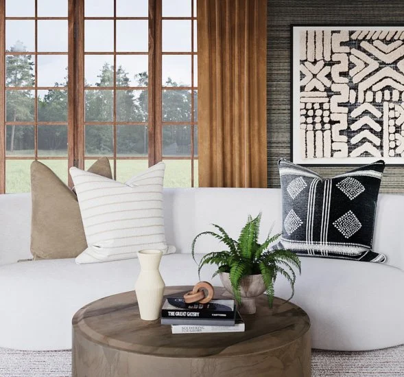 Neutral and black patterned throw pillows styled on a curved sofa in a modern organic living room designed by virtual interior designer Joshua Jones of JJones Design Co.