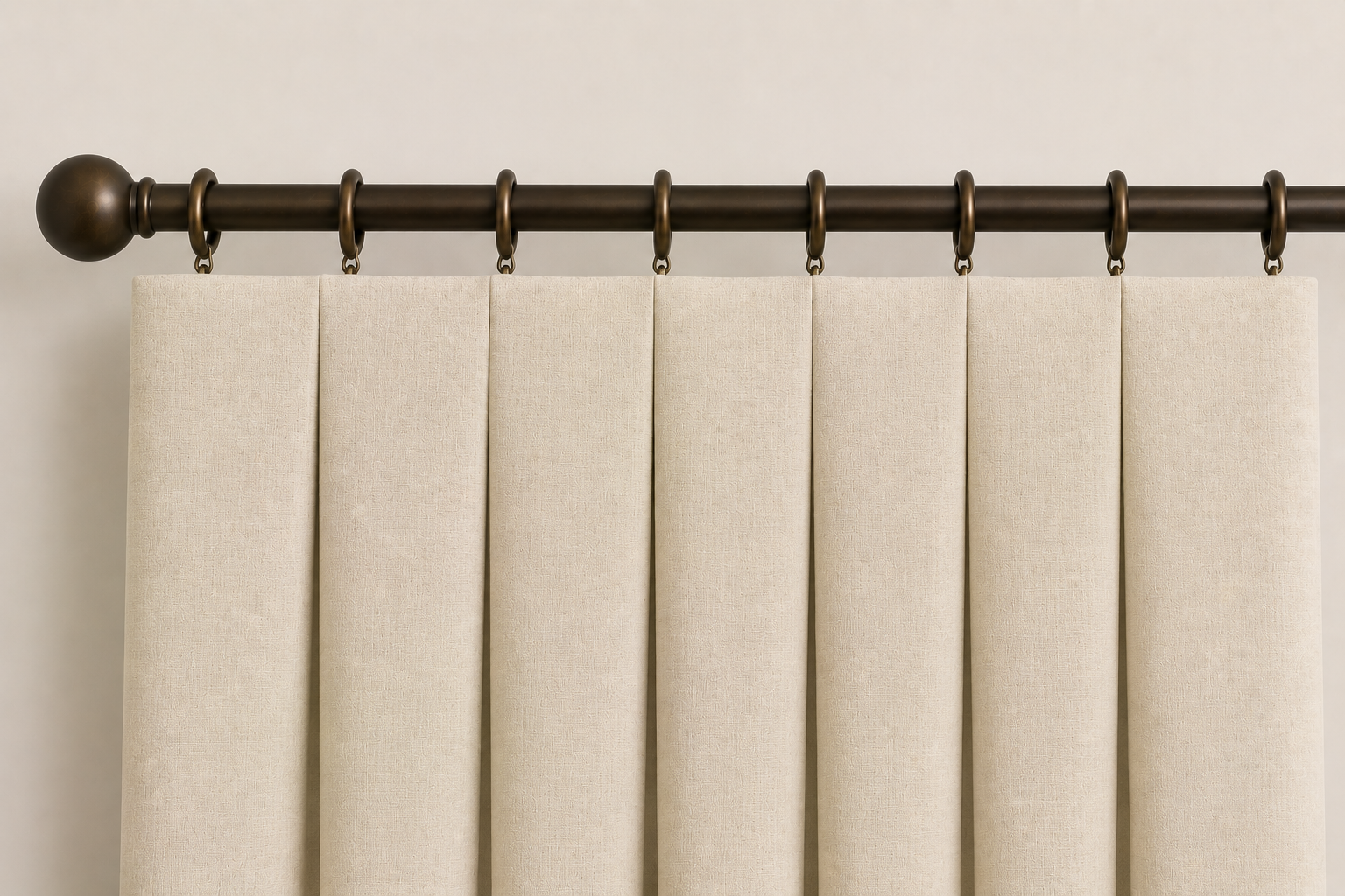 Close-up AI rendering of an inverted box pleat drapery header featuring cream fabric panels with flat front-facing sections and folds tucked behind the fabric, suspended from decorative bronze rings and a matching drapery rod.
