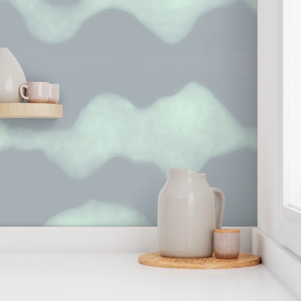Mockup of a minimalist Scandinavian-style kitchen nook with “Cascades” wallpaper in large scale, dark mint and mint colorway—pattern designed by Joshua Jones of JJones Design Co., shown with ceramic pitcher, cup, and wood tray near a window.