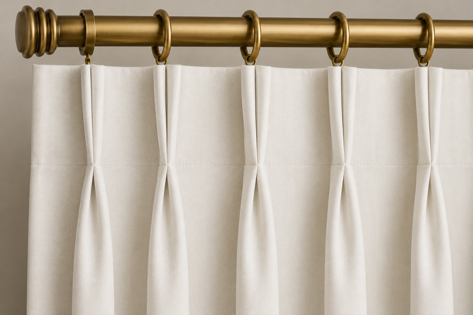 Close-up AI rendering of a cream Euro pleat drapery header attached to decorative curtain rings on an antique brass drapery rod, showing pleats sewn at the top of the panel for a clean and tailored appearance.