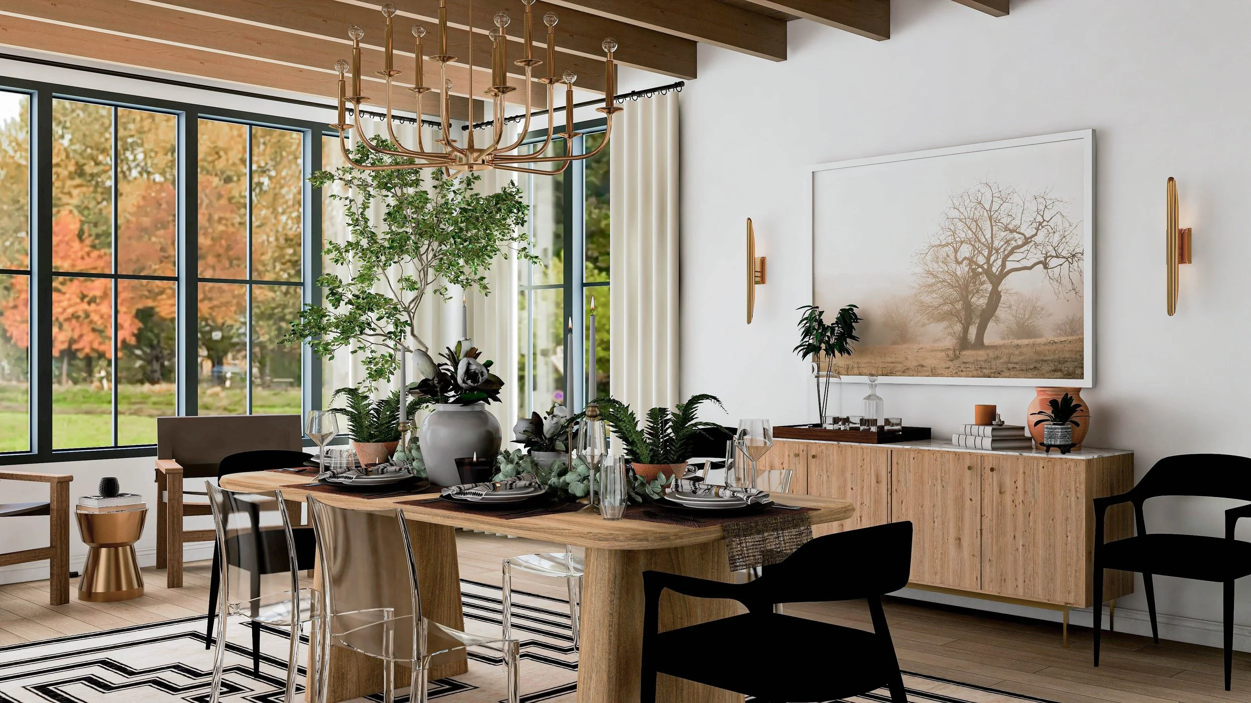 Rustic glam dining room designed by Joshua Jones showing a styled wood dining table with candles and greenery, ghost chairs mixed with black dining chairs, brass chandelier, and a modern wood sideboard with large artwork above.