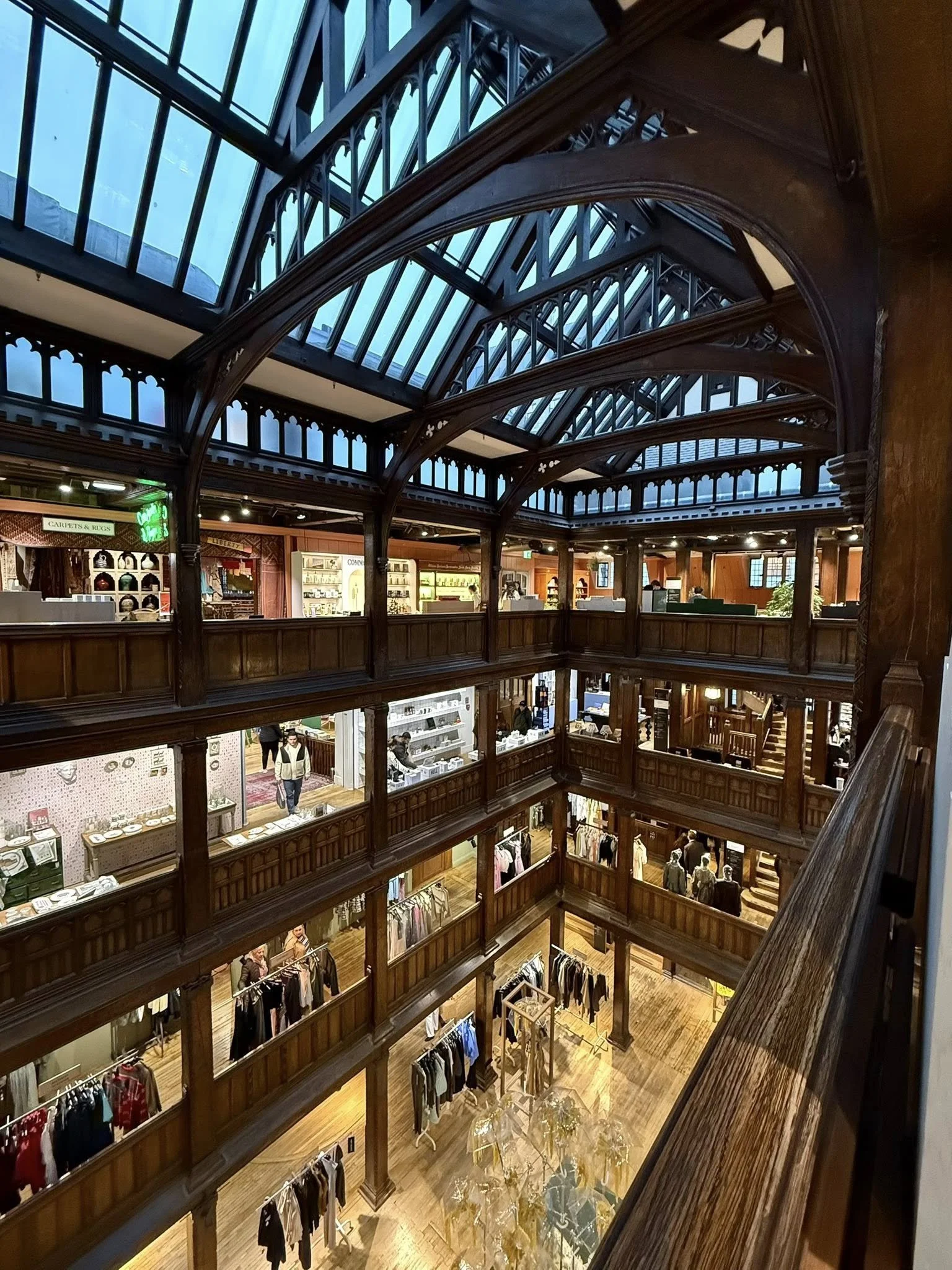 Interior of Liberty London showing wooden Tudor-style architecture, open atrium, and multiple levels of retail space