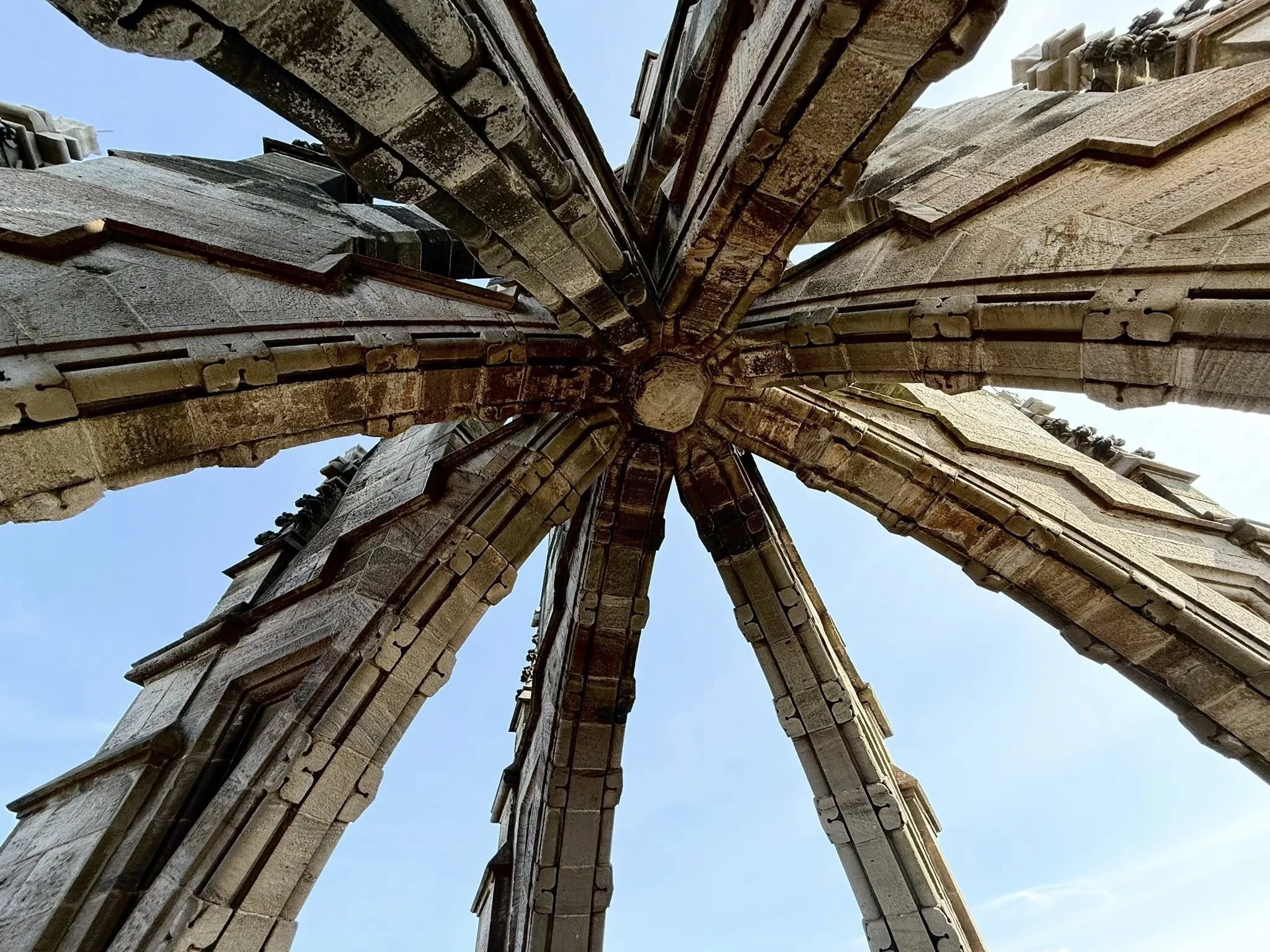 View looking up at the open-air crown of the National Wallace Monument in Stirling, showing intersecting stone arches against the sky