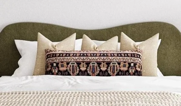 Patterned lumbar pillow layered with neutral pillows on a bed in a modern eclectic bedroom designed by virtual interior designer Joshua Jones of JJones Design Co.