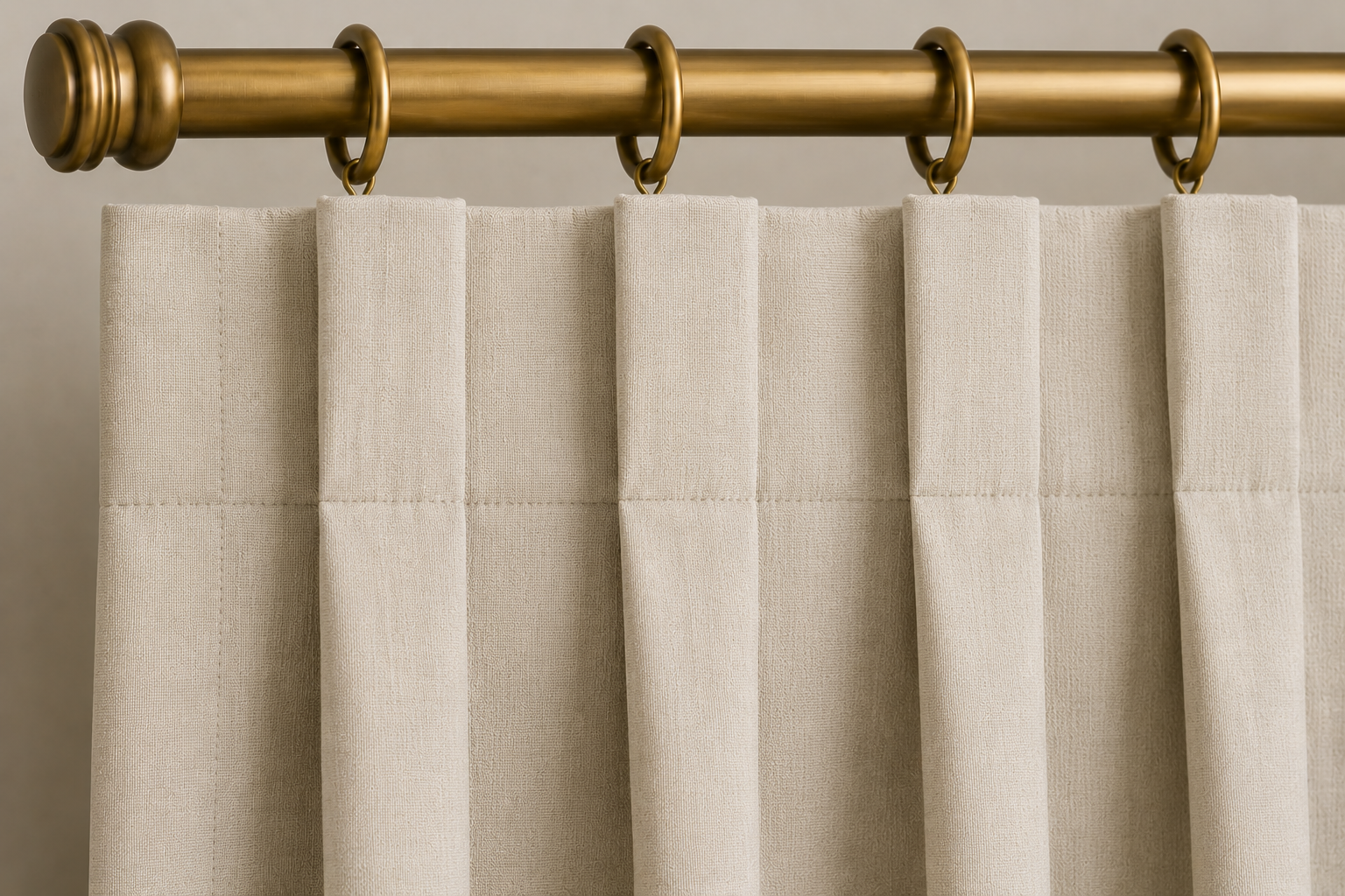 Close-up AI rendering of a cream box pleat drapery header attached to decorative curtain rings on an antique brass drapery rod, showing evenly spaced pleats folded outward to create a tailored and structured appearance.