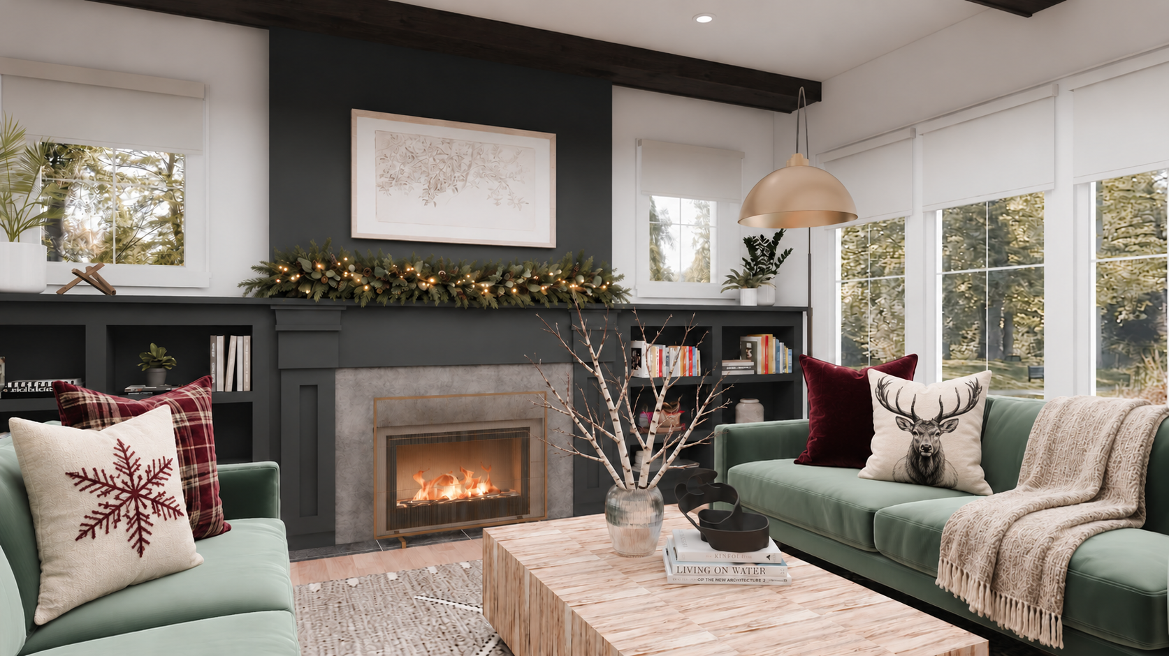 Sage green sofas with burgundy, plaid, snowflake, and black-and-white elk pillows, an oatmeal throw, birch branches on the coffee table, and lit mantel garland.