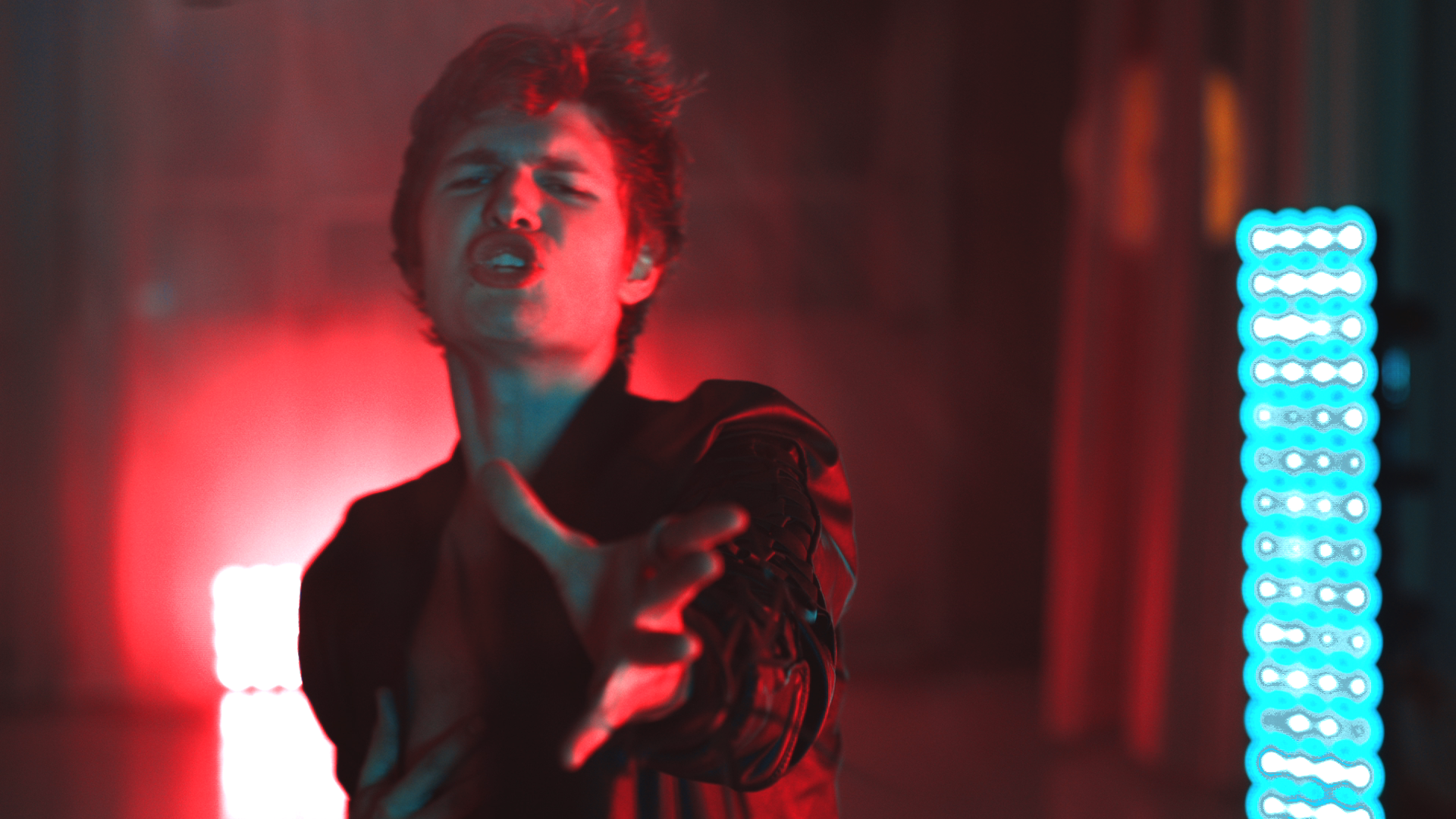 Red glowing Ansel Elgort reaches for the camera