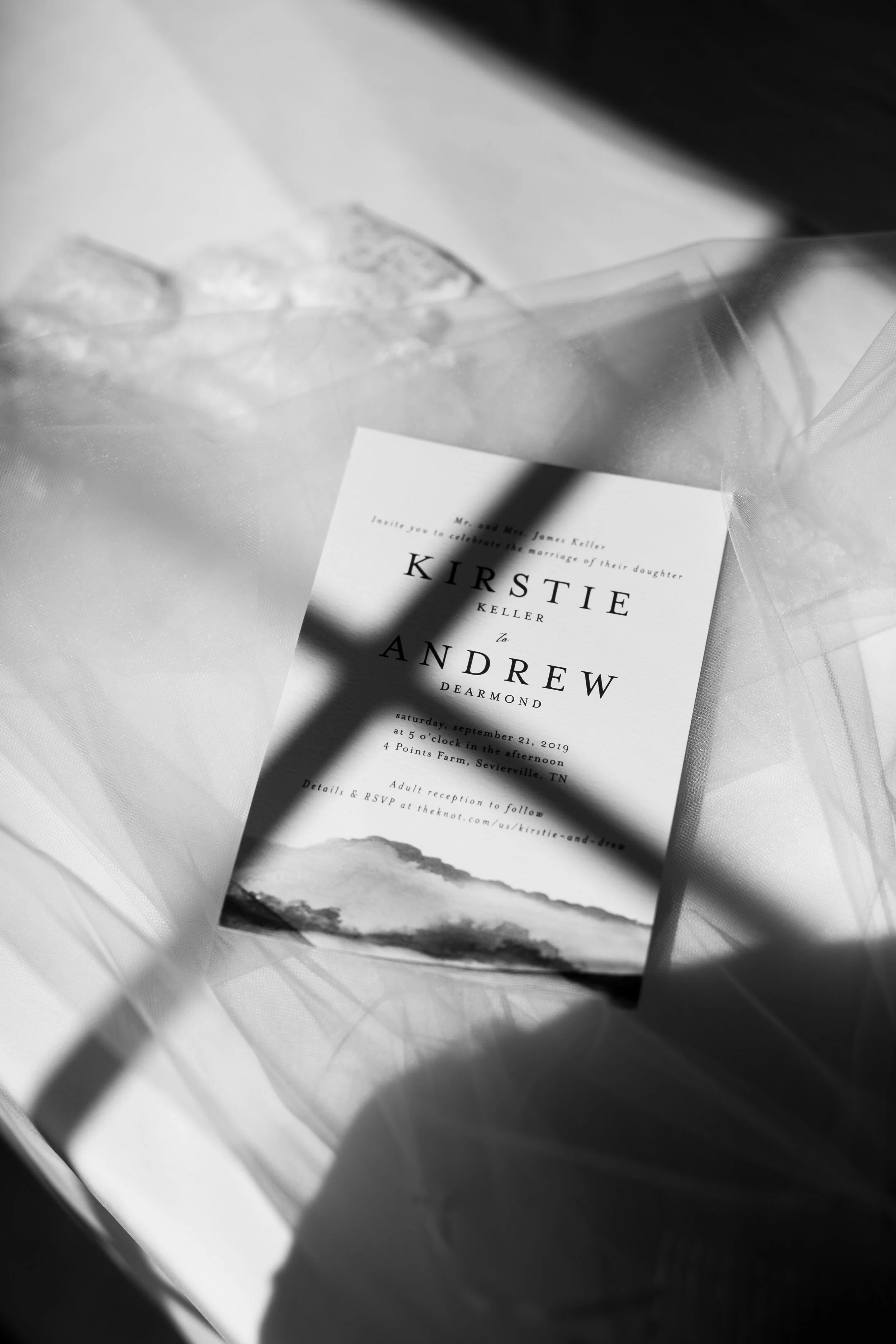 black and white invitation in window light