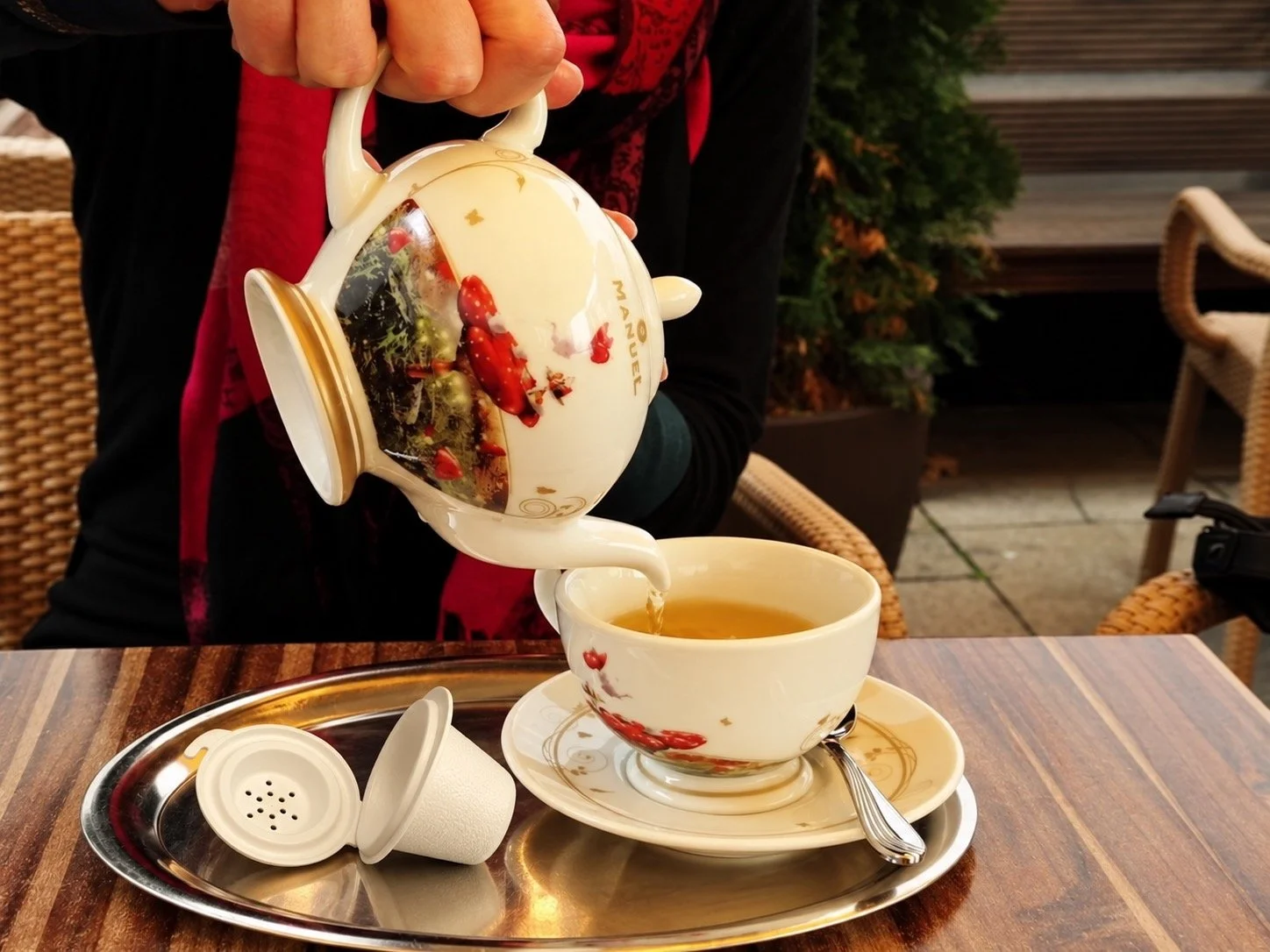 Tea is being pouring  from a classic teapot into a cup. Chadan is close to the cup