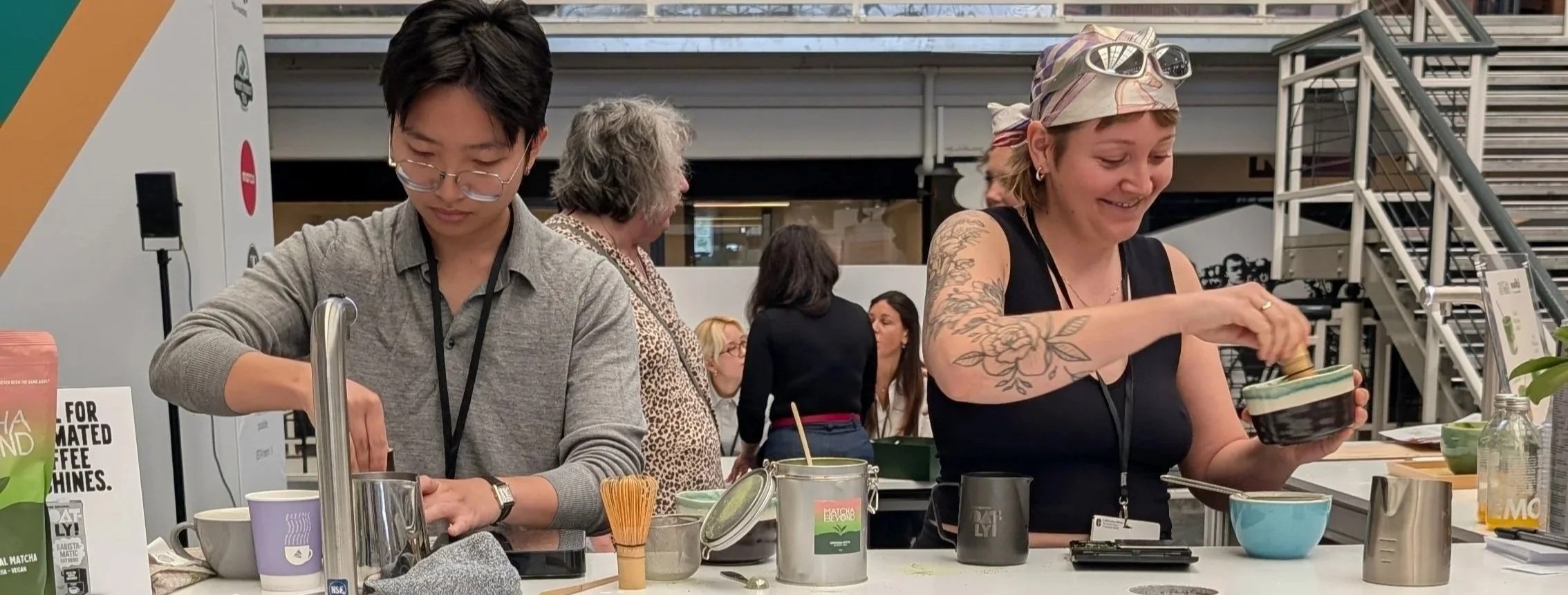 Two people are preparing matcha latte at a counter in Caffe Culture Show