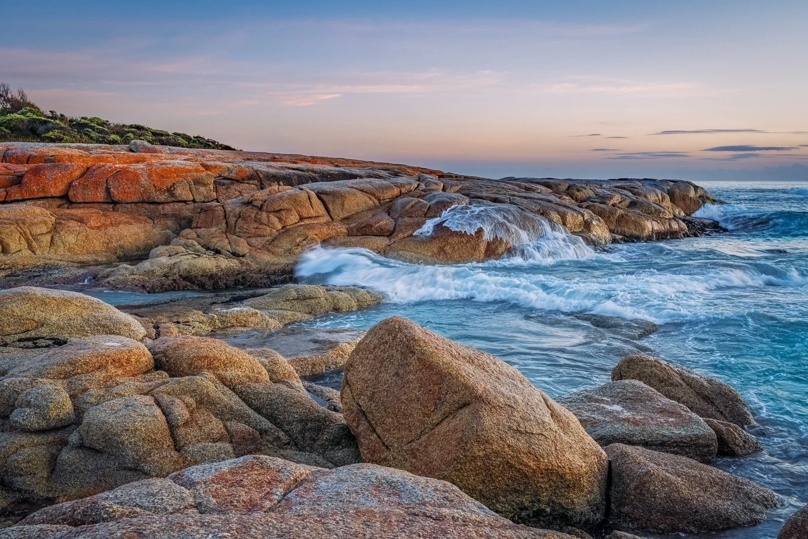 &ldquo;Sunrise Washover&rdquo;

Sunrise / Bay of Fires, Tasmania, Australia .

A soft, pastel sunrise enhanced by those bold, bright lichen rocks AND stunning aquamarine sea colours!
And a half moon bidding farewell!

And &hellip; there I was camped 