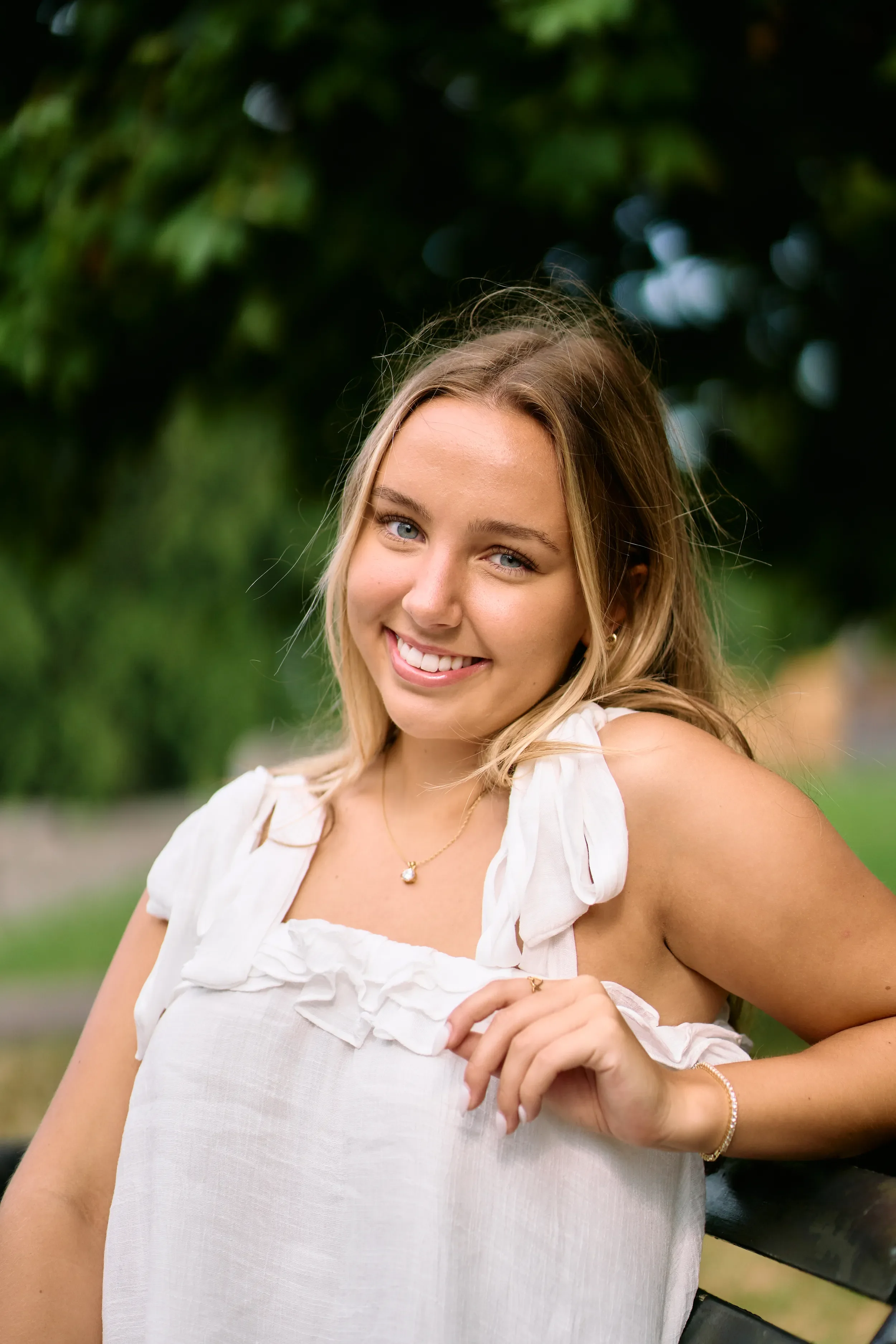 Smiling high school senior portrait on a tree-lined path in Kensington Gardens, London